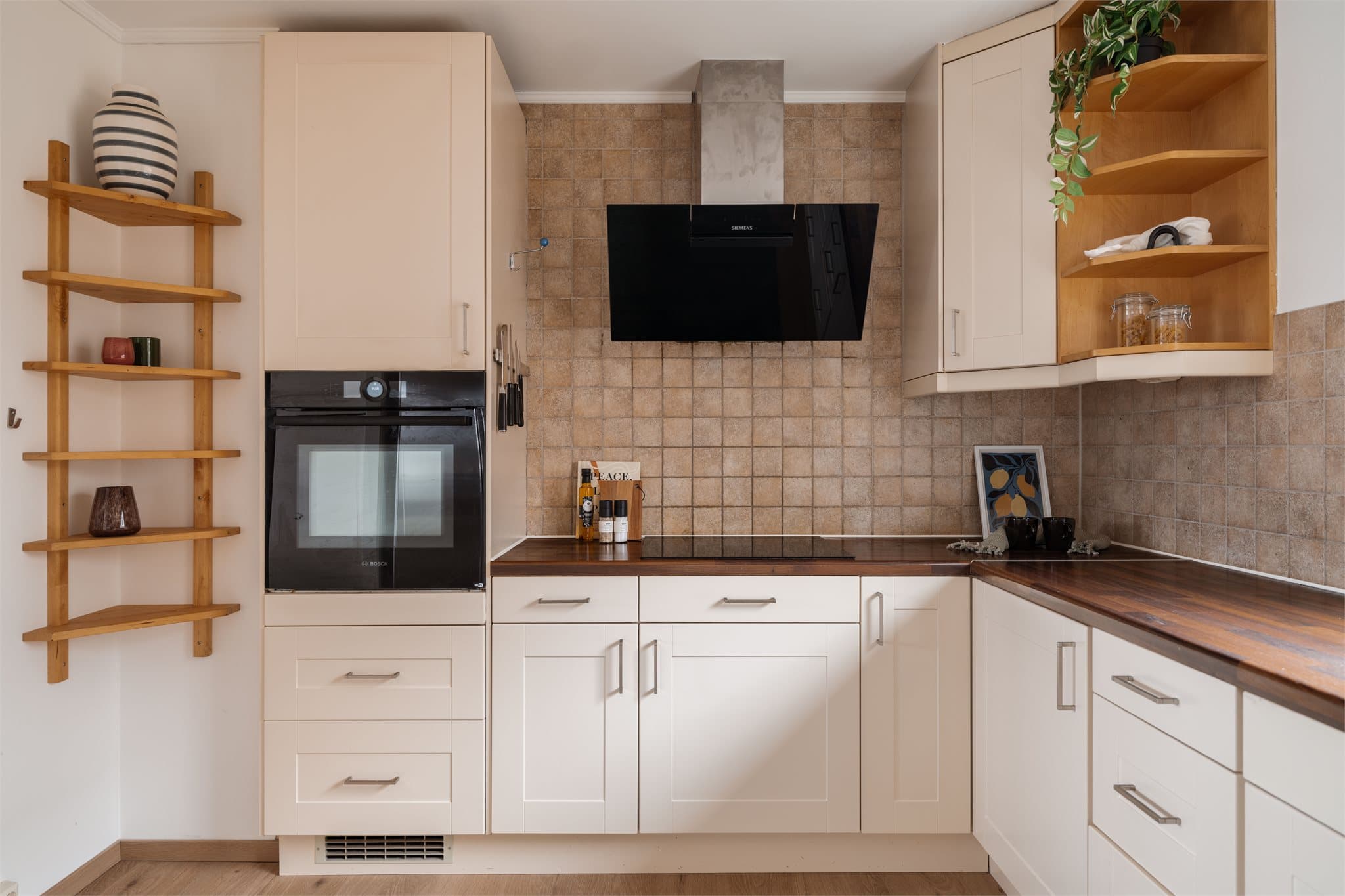 Innredningen har glatte fronter, benkeplate i laminat og integrert stekeovn og platetopp.