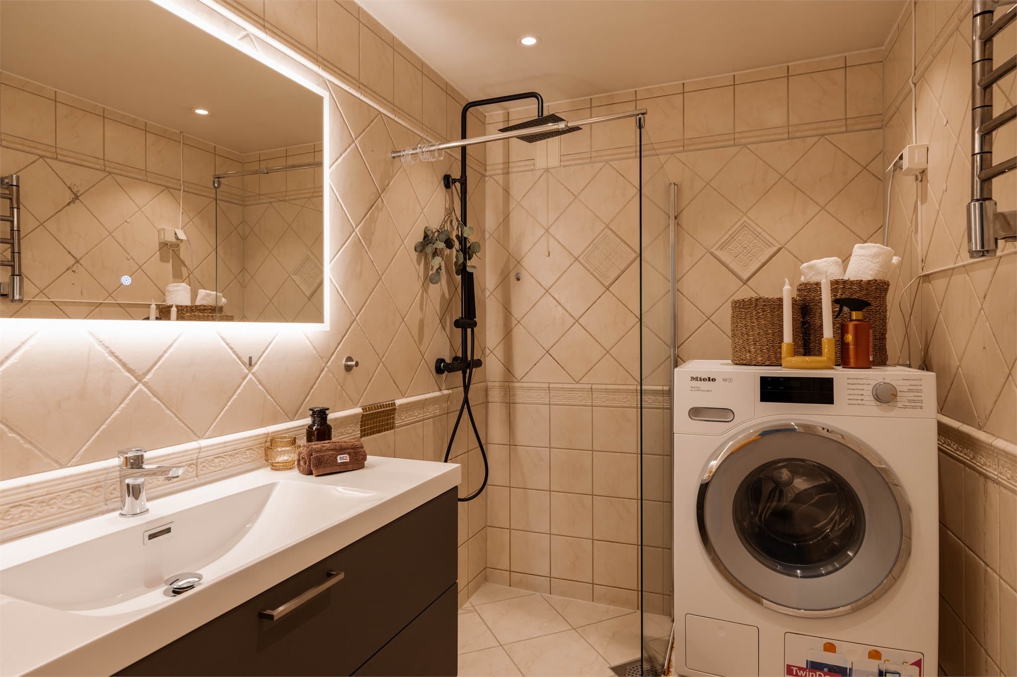 Rommet har innredning med nedfelt servant, dusjhjørne og opplegg for vaskemaskin.