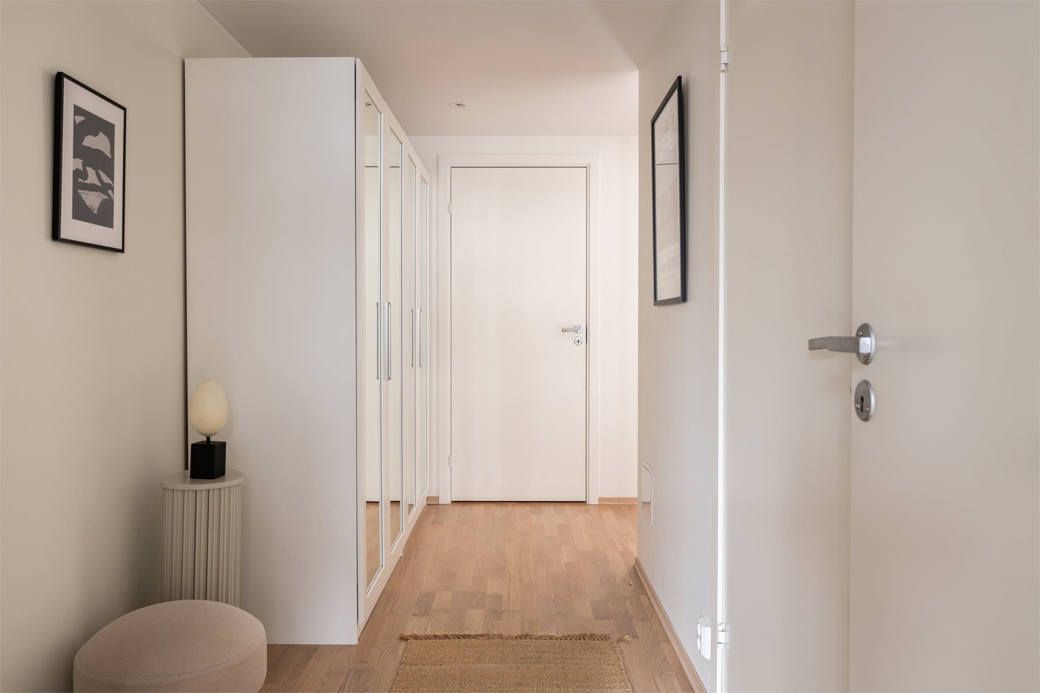 En innbydende entré med 3-stavs parkett og downlights i himlingen ønsker deg velkommen.