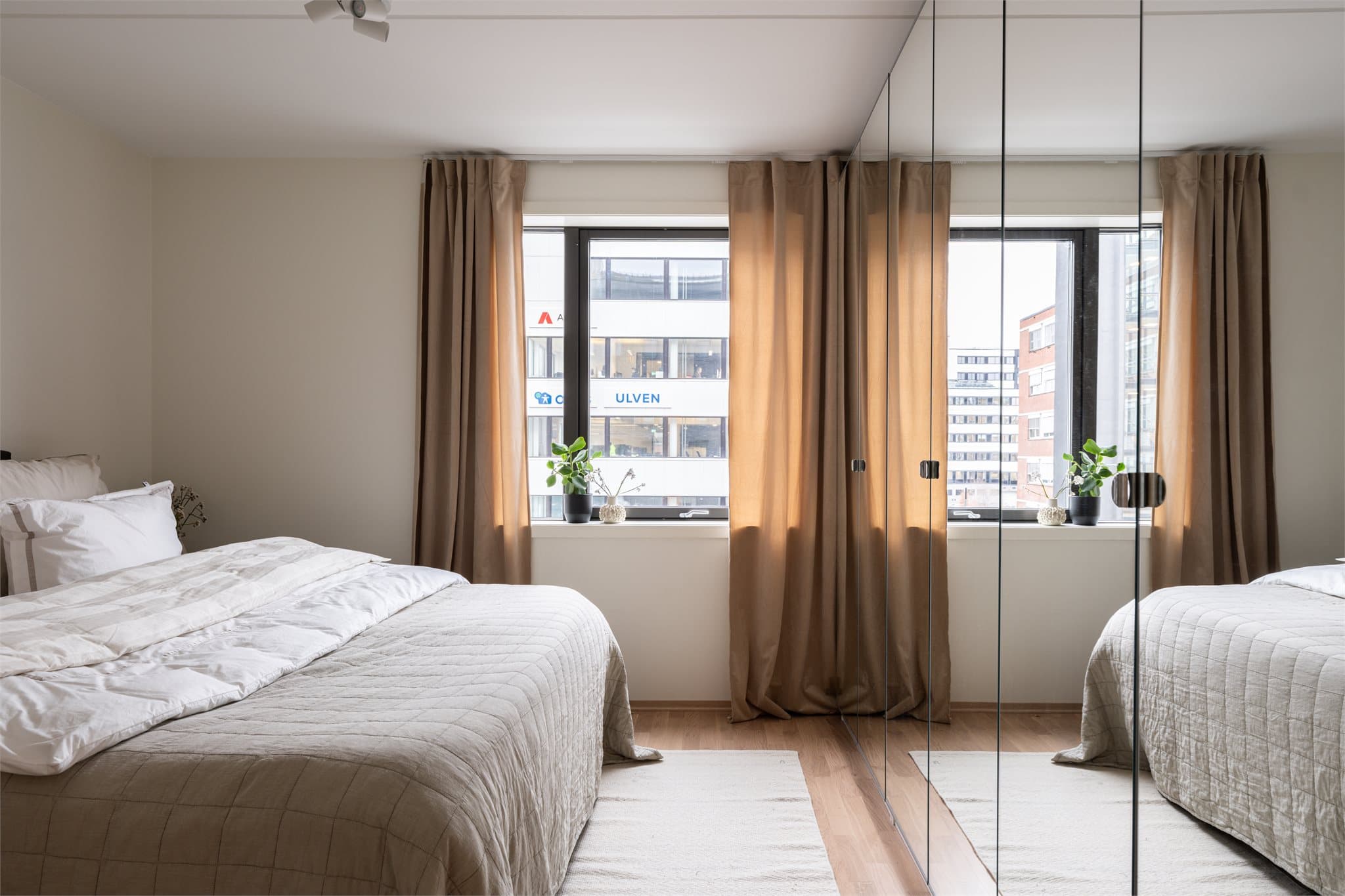 Store garderobeskap med speilfronter gir rikelig med oppbevaring og en god romfølelse.