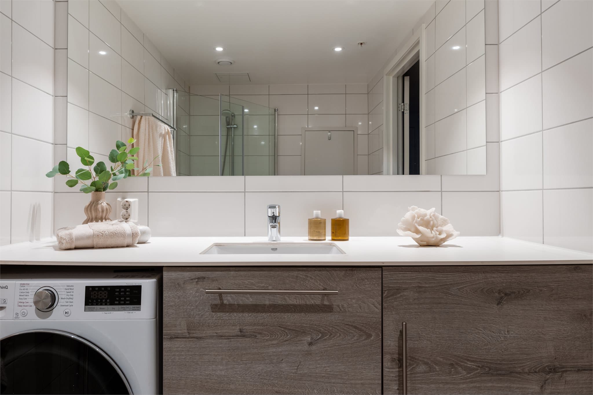 Innredning med underlimt servant og praktisk opplegg for vaskemaskin under benkeplaten.