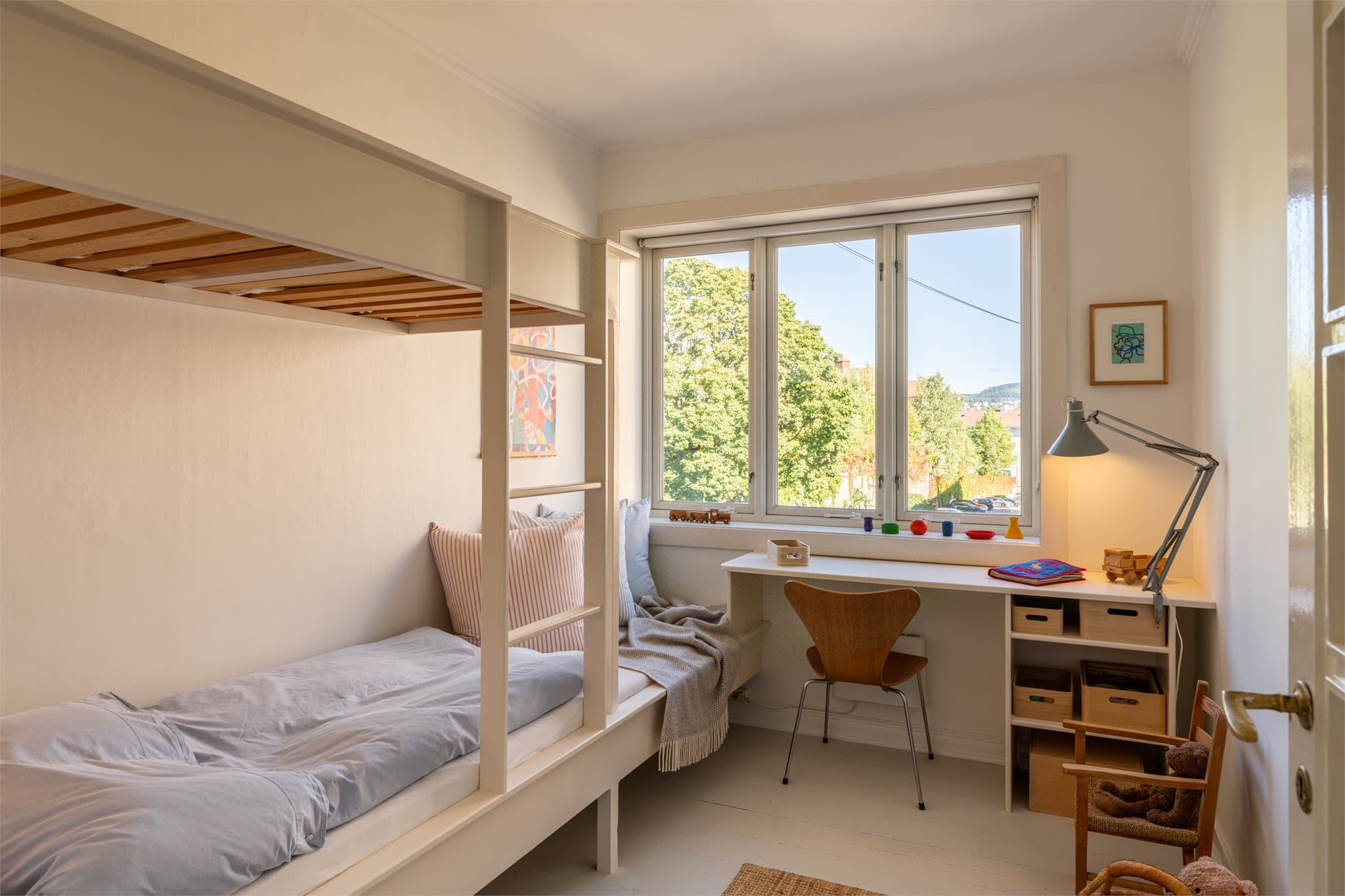 Soverom nummer to er arealeffektivt innredet med plassbygd køyeseng samt skrivebord med hyller, noe som utnytter rommet på en funksjonell måte.