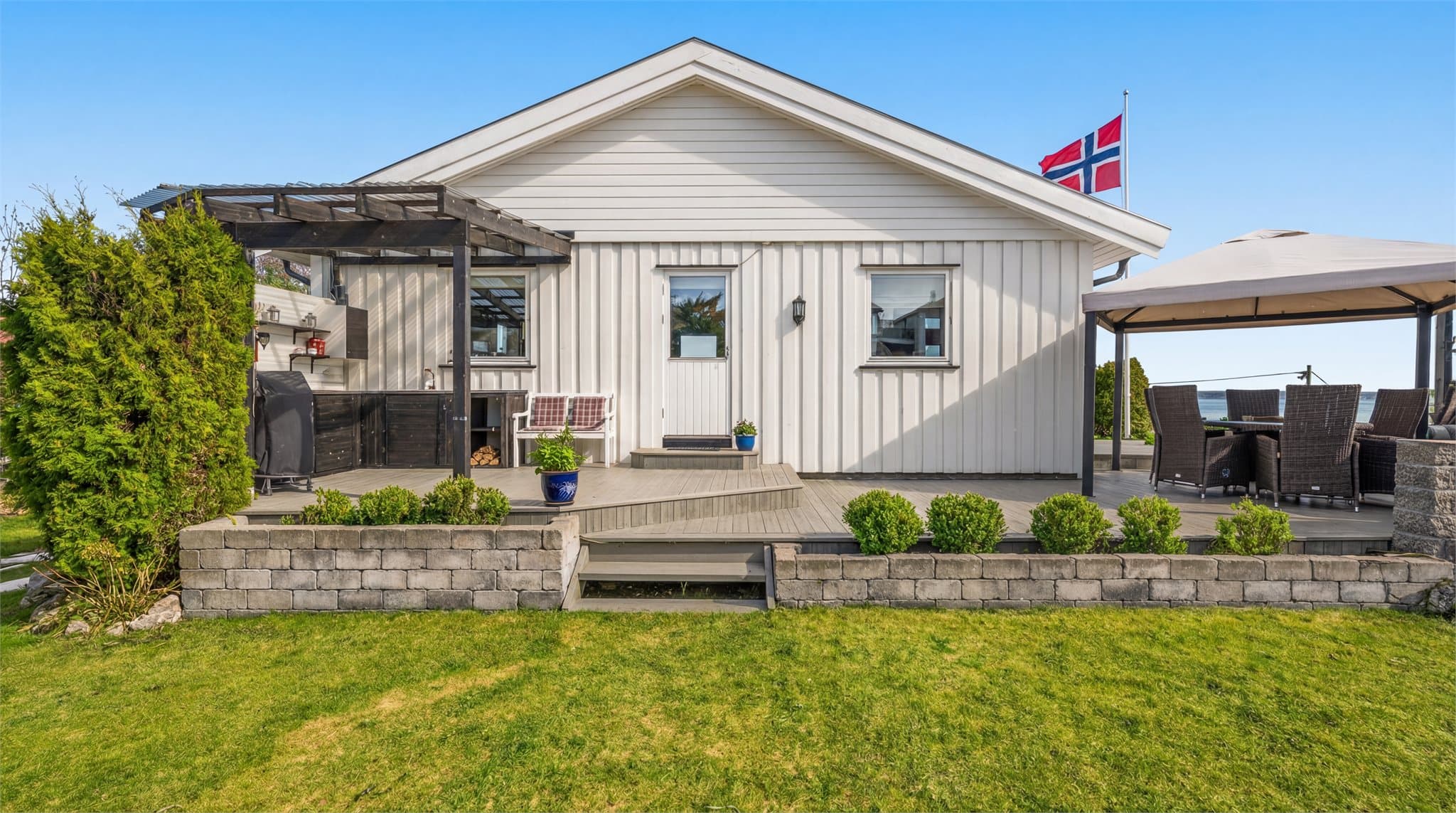 Fasade fra baksiden hvor det er utgang til terrasse og hage