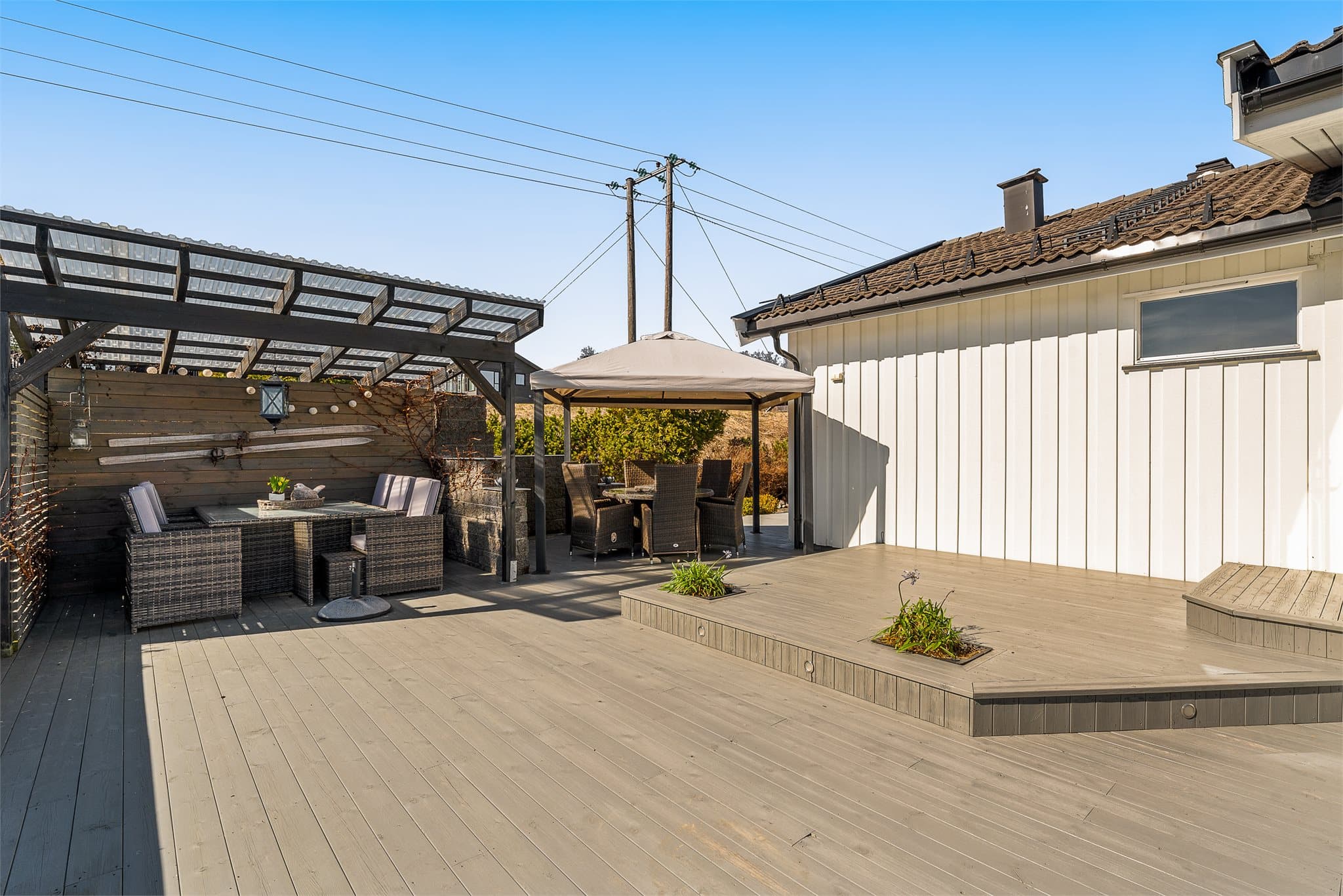 Stor terrasse med mye sol. Det er satt opp to pergolaer