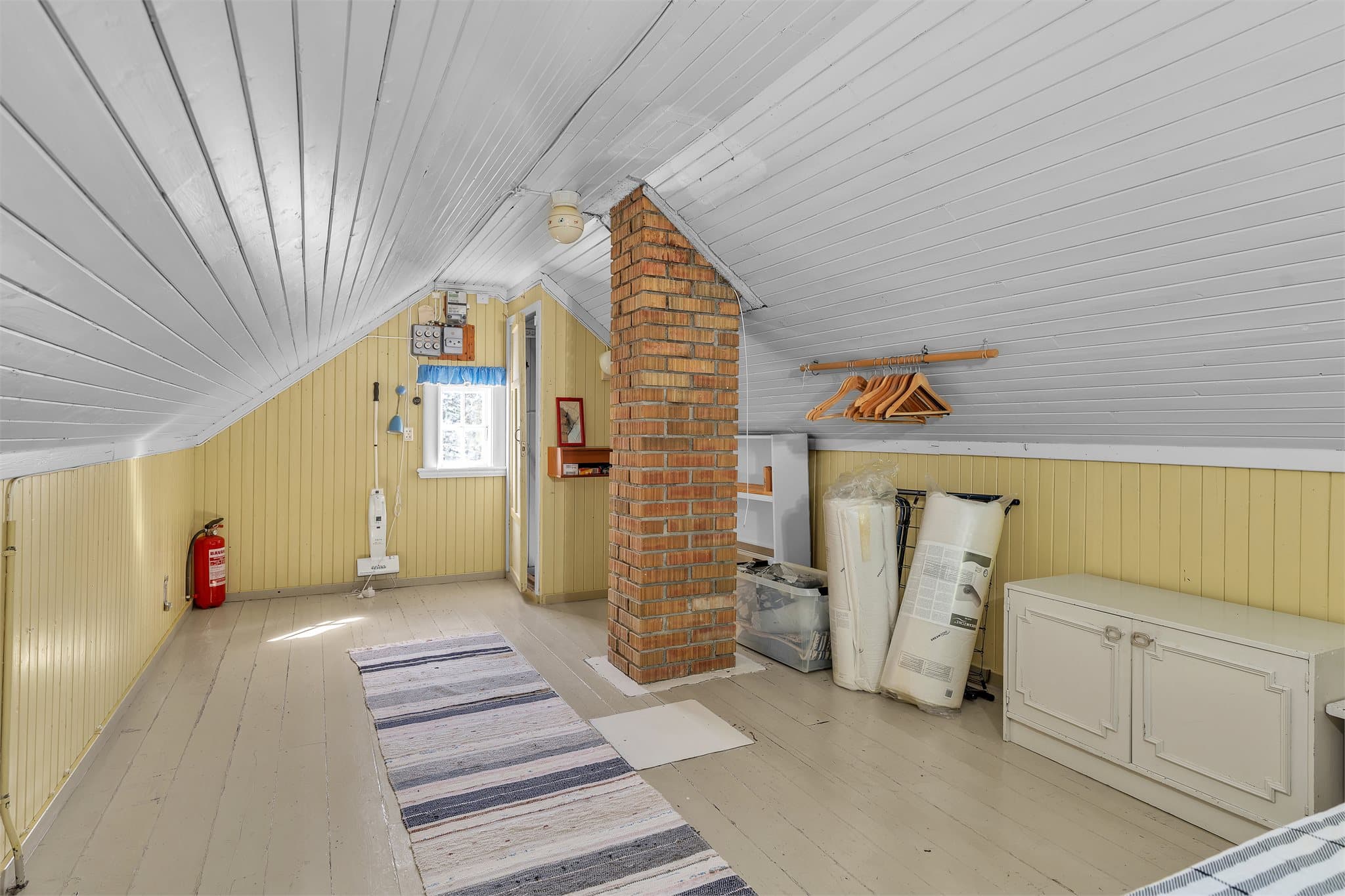 Loftet er et åpent og fleksibelt rom med trepanel på vegger og malt himling.