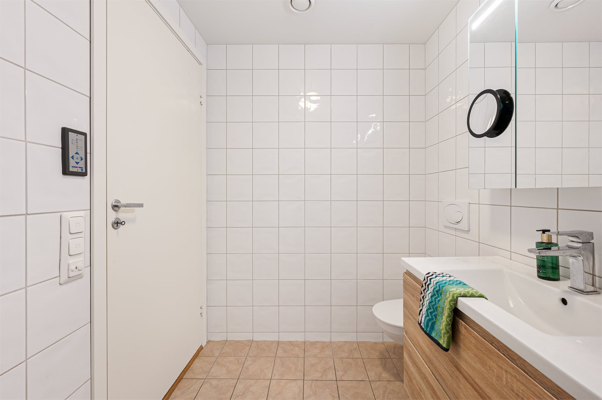 - Badet er innredet med heldekkende servant, vegghengt toalett, dusjhjøne, speilskap og opplegg for vaskemaskin -