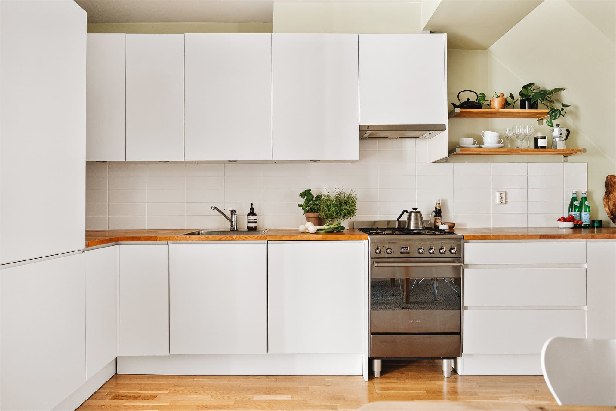 Gjennomført kjøkken med integrerte hvitevarer, god skapplass og tidløse materialvalg