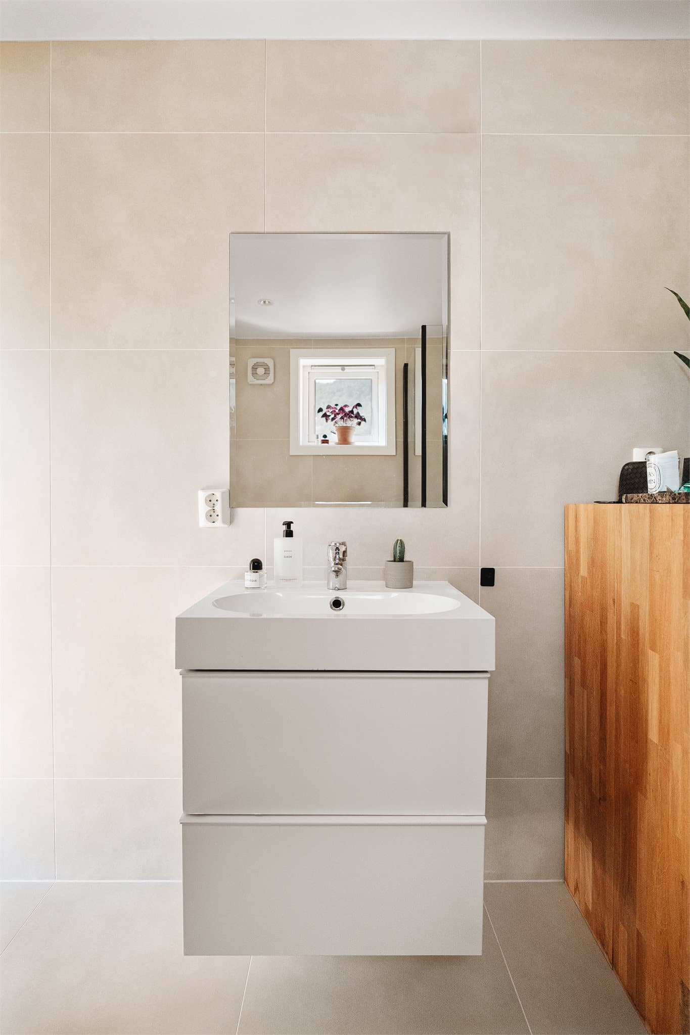 Badet er innredet med et pent baderomsmøbel med slette fronter, heldekkende servant og ett-greps blandebatteri