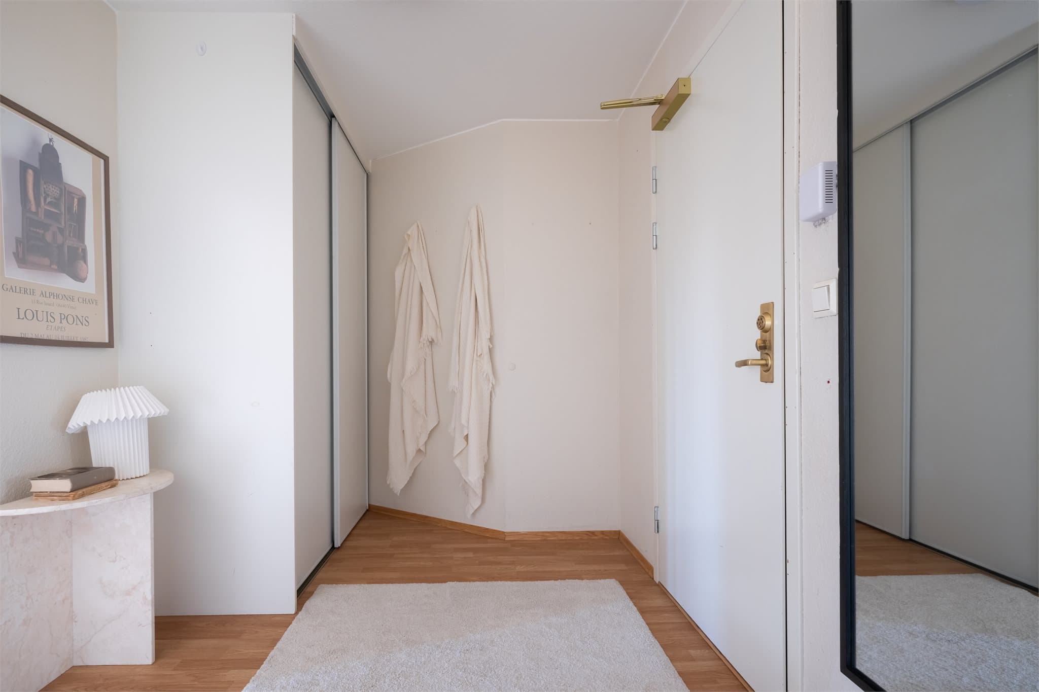 Leiligheten har en romslig entré med plass til oppbevaring og møblering. Her er det en praktisk skyvedørsgarderobe som sørger for effektiv lagringsplass til yttertøy og sko.