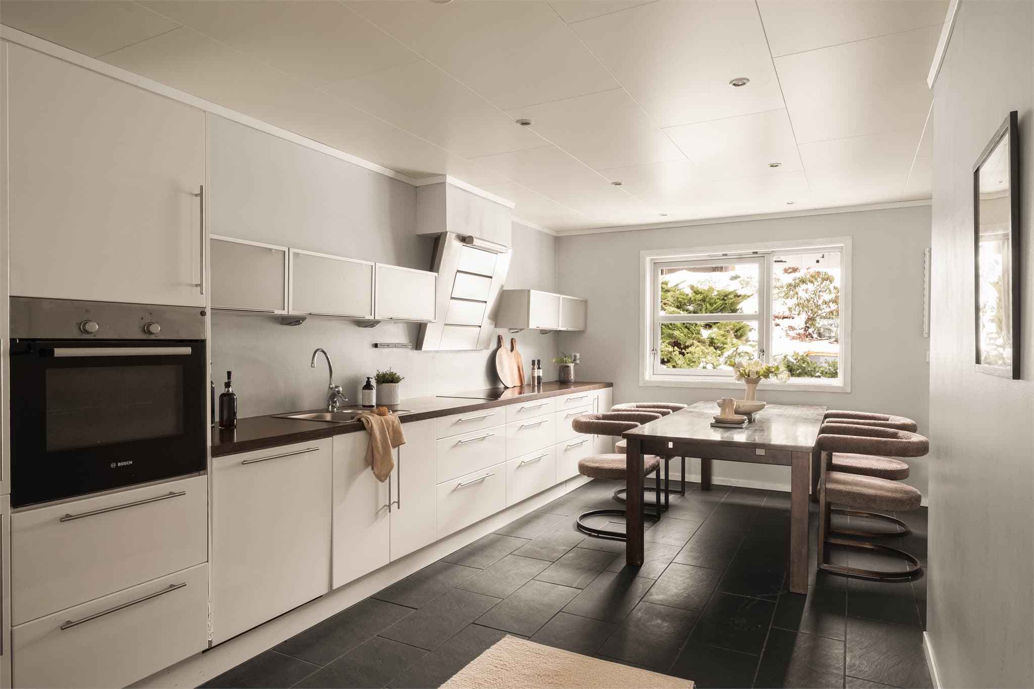 - Lekker kjøkkeninnredning med slette fronter i høyglans og benkeplate i laminat -