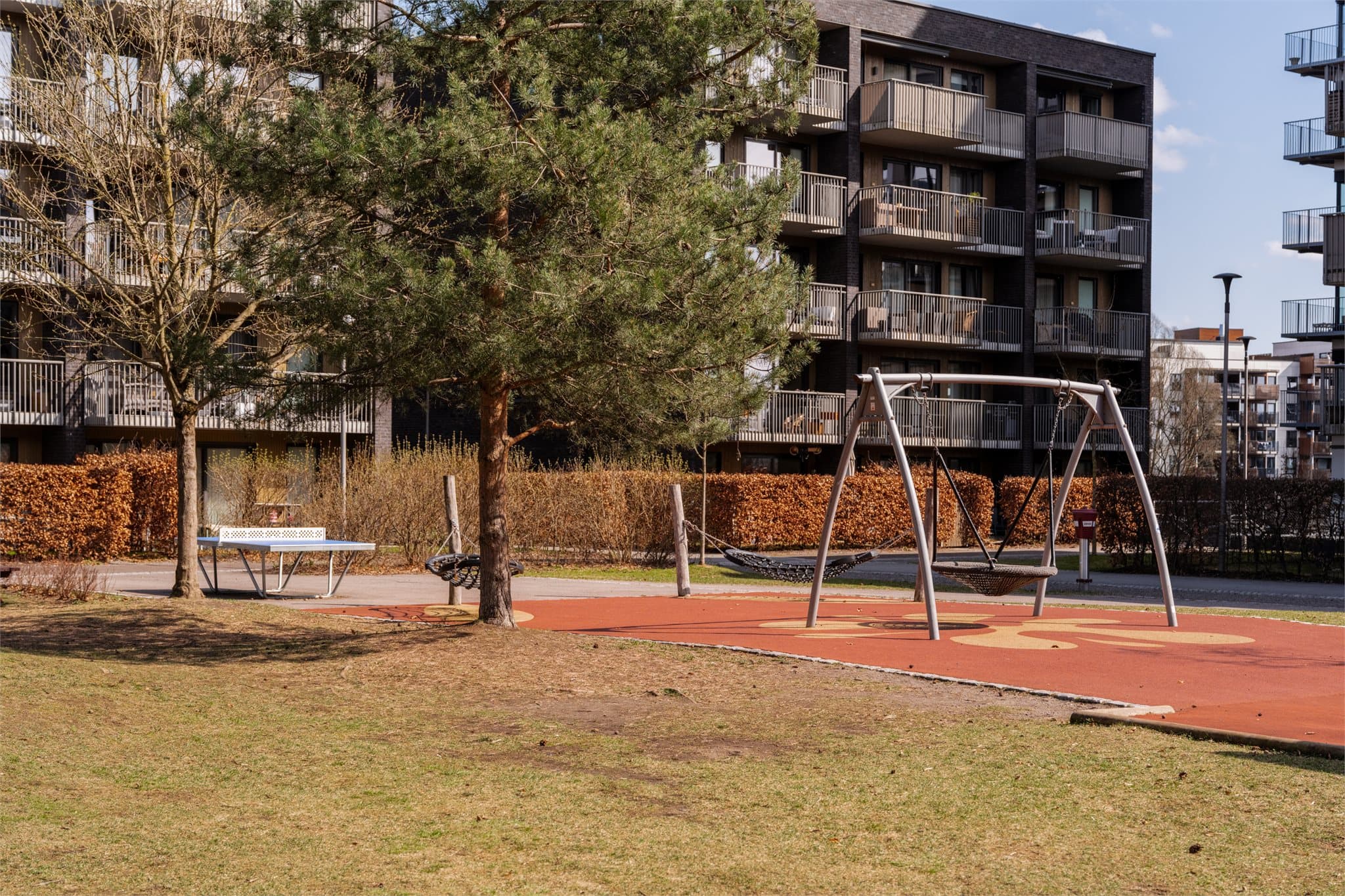 Bordtennisbord, husker og flere lekeområder gjør uteplassen attraktiv for barna.