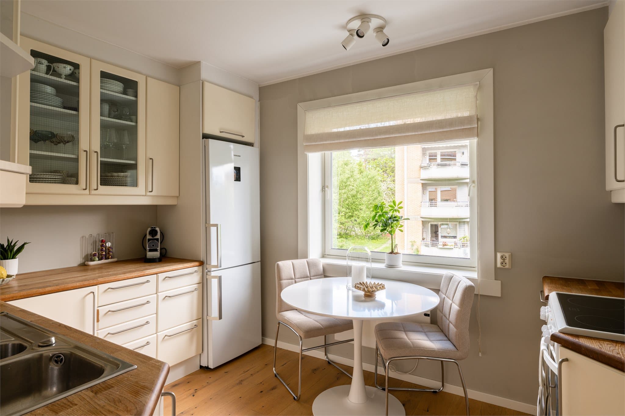 Kjøkkenet ligger i et separat rom og har innredning med lyse fronter og benkeplate i heltre.