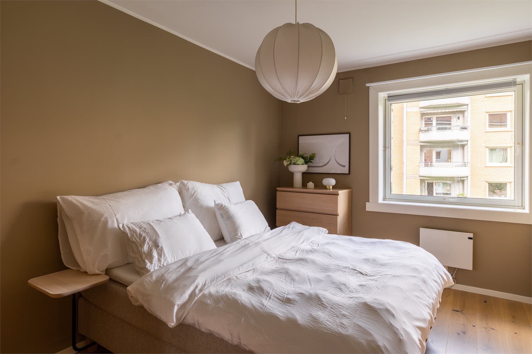 Lekkert hovedsoverom med plass til en stor dobbeltseng med nattbord på sidene.