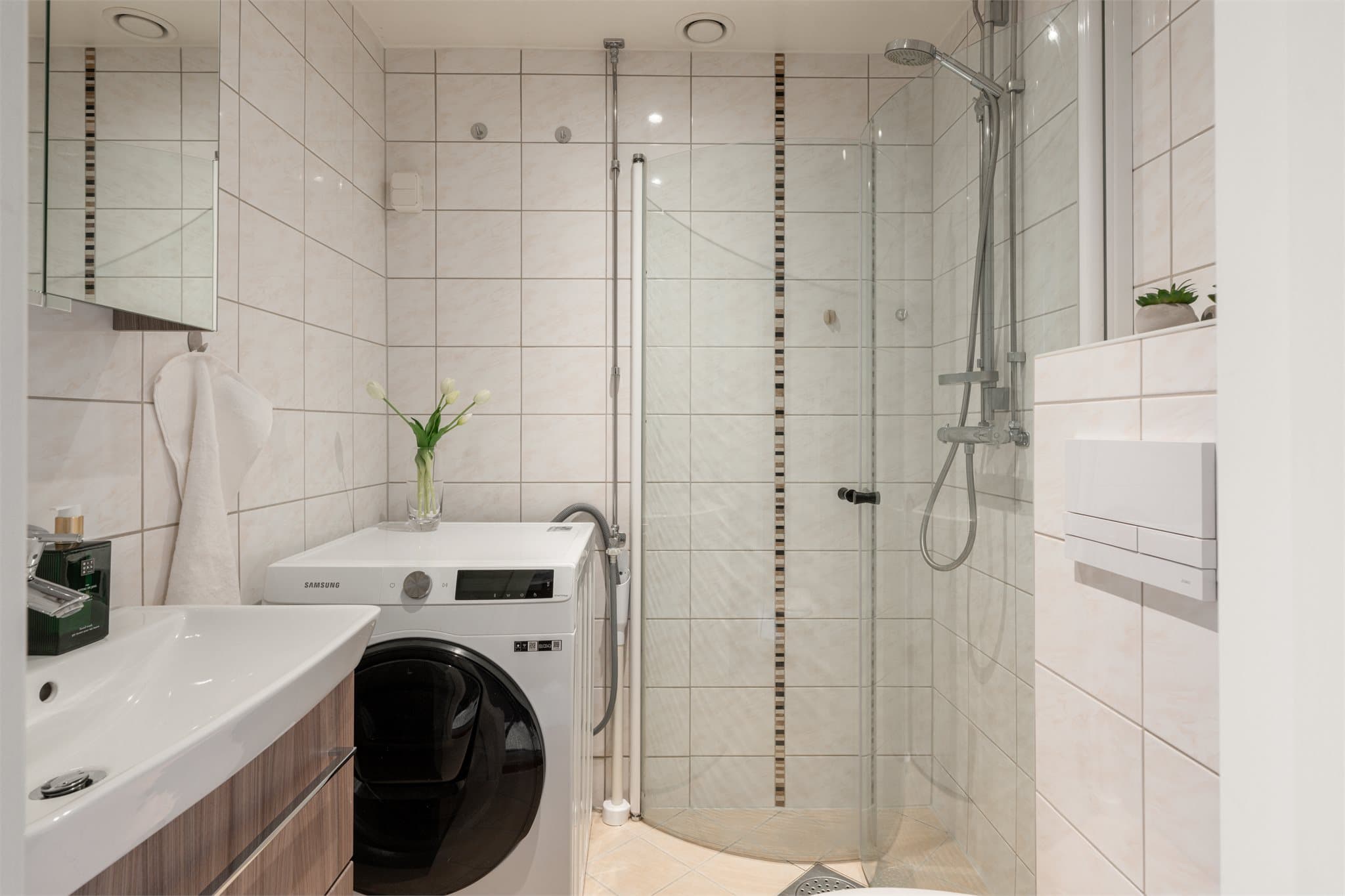 Badet har flislagte gulv, flislagte vegger, malt gipstak med downlights og elektriske varmekabler i gulv.