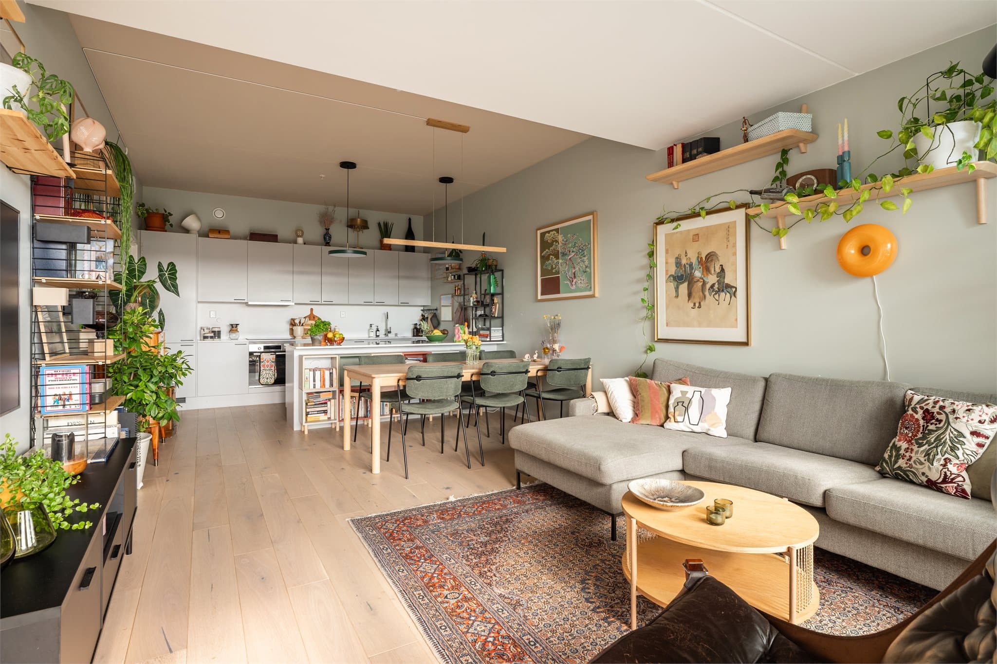 Et innbydende oppholdsrom med behagelige farger og en flott eikeparkett.