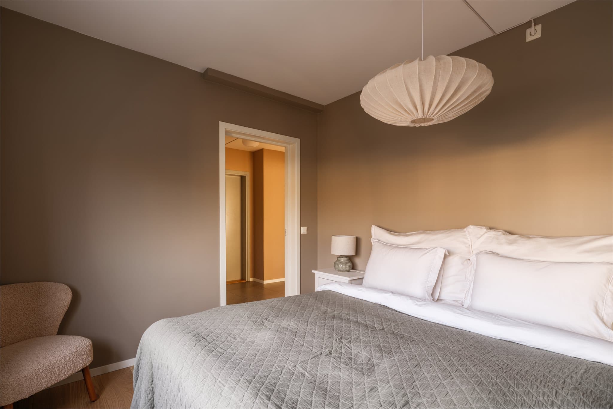 Et harmonisk og behagelig rom med plass til en stor seng og ekstra møblering.