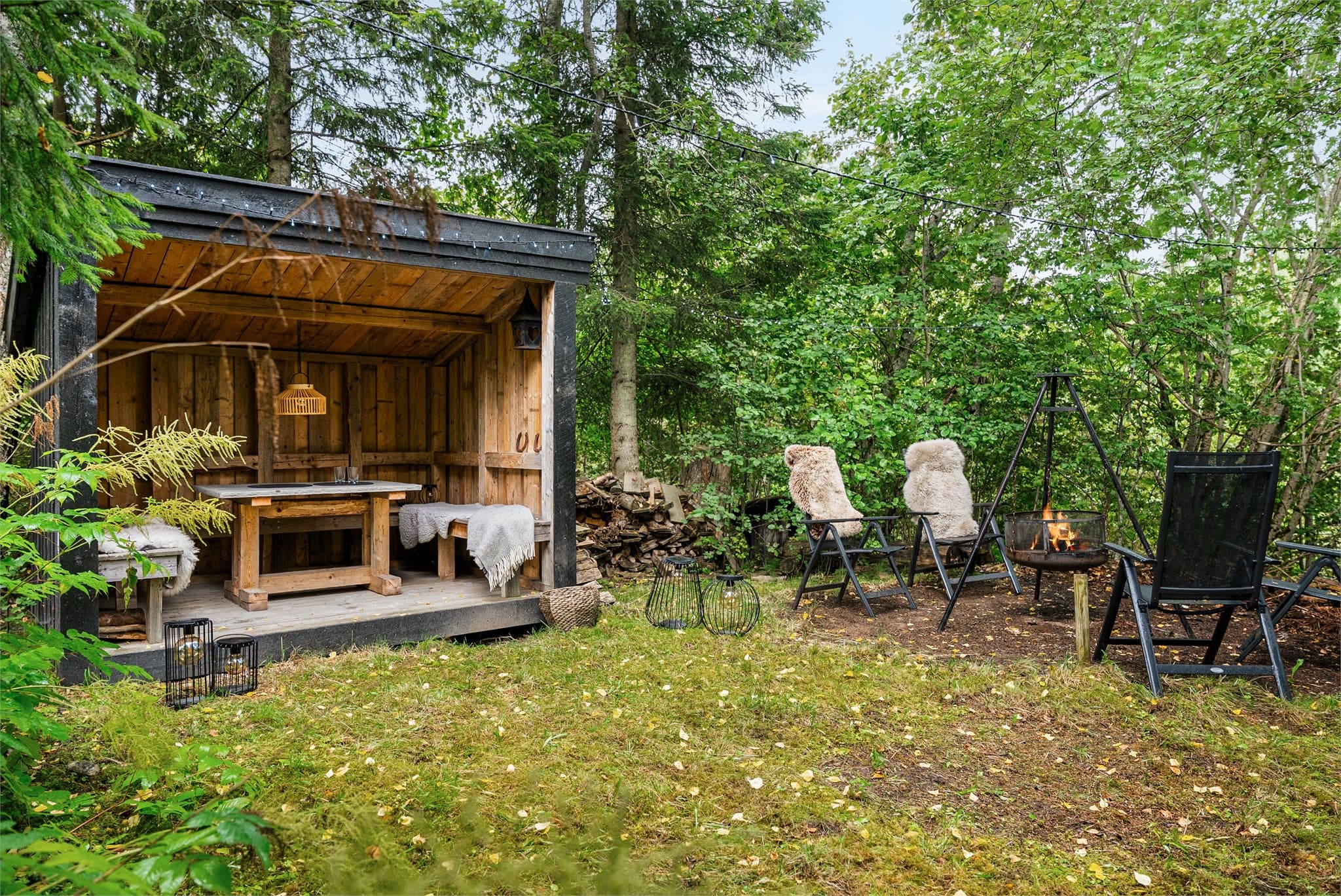 På nedsiden av huset finner du en flott og lun uteplass med overbygd sitteplass, perfekt for hyggelige kvelder utendørs.