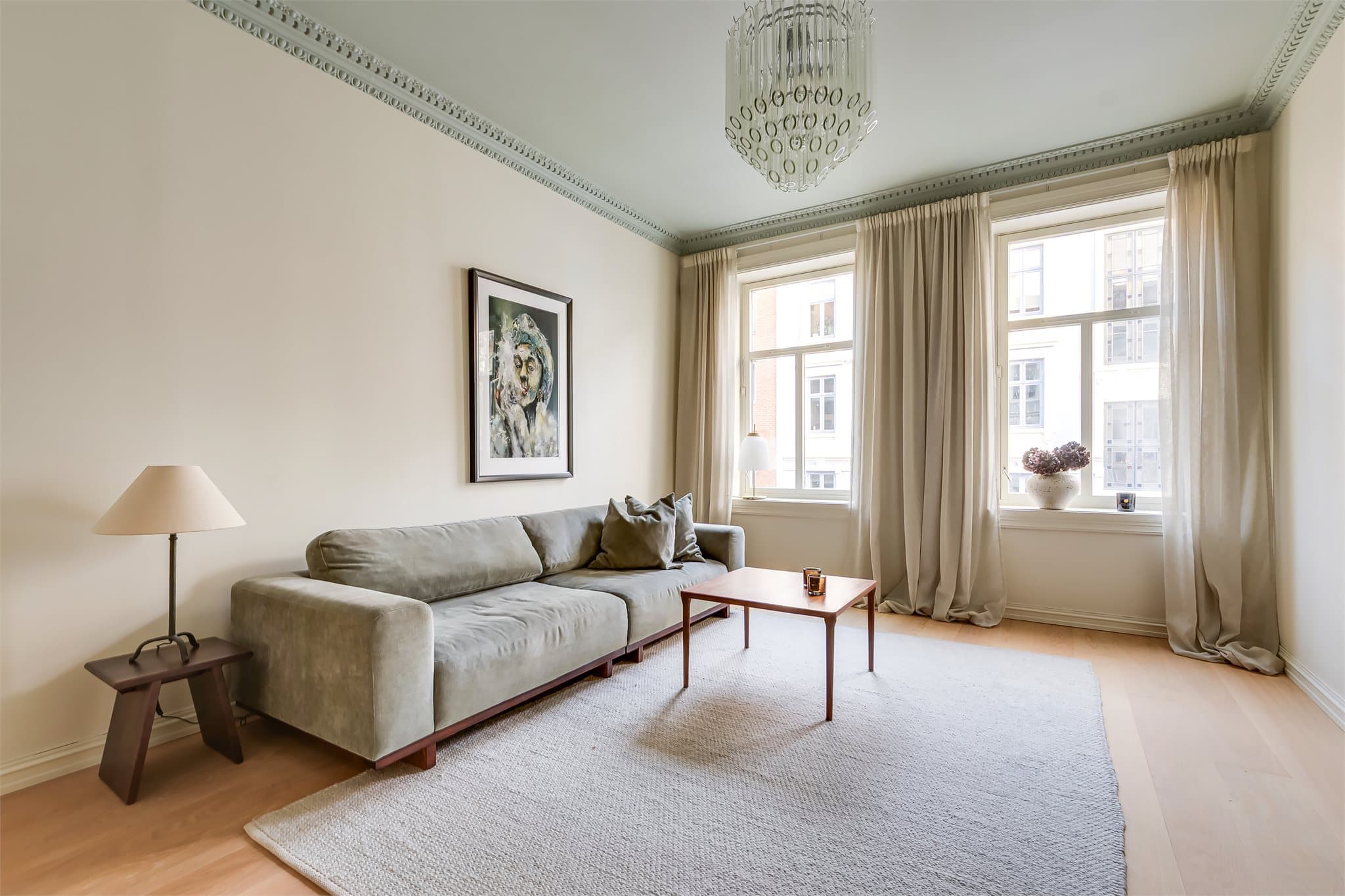 De store vinduene i kombinasjon med takhøyden gjør stuen svært luftig.