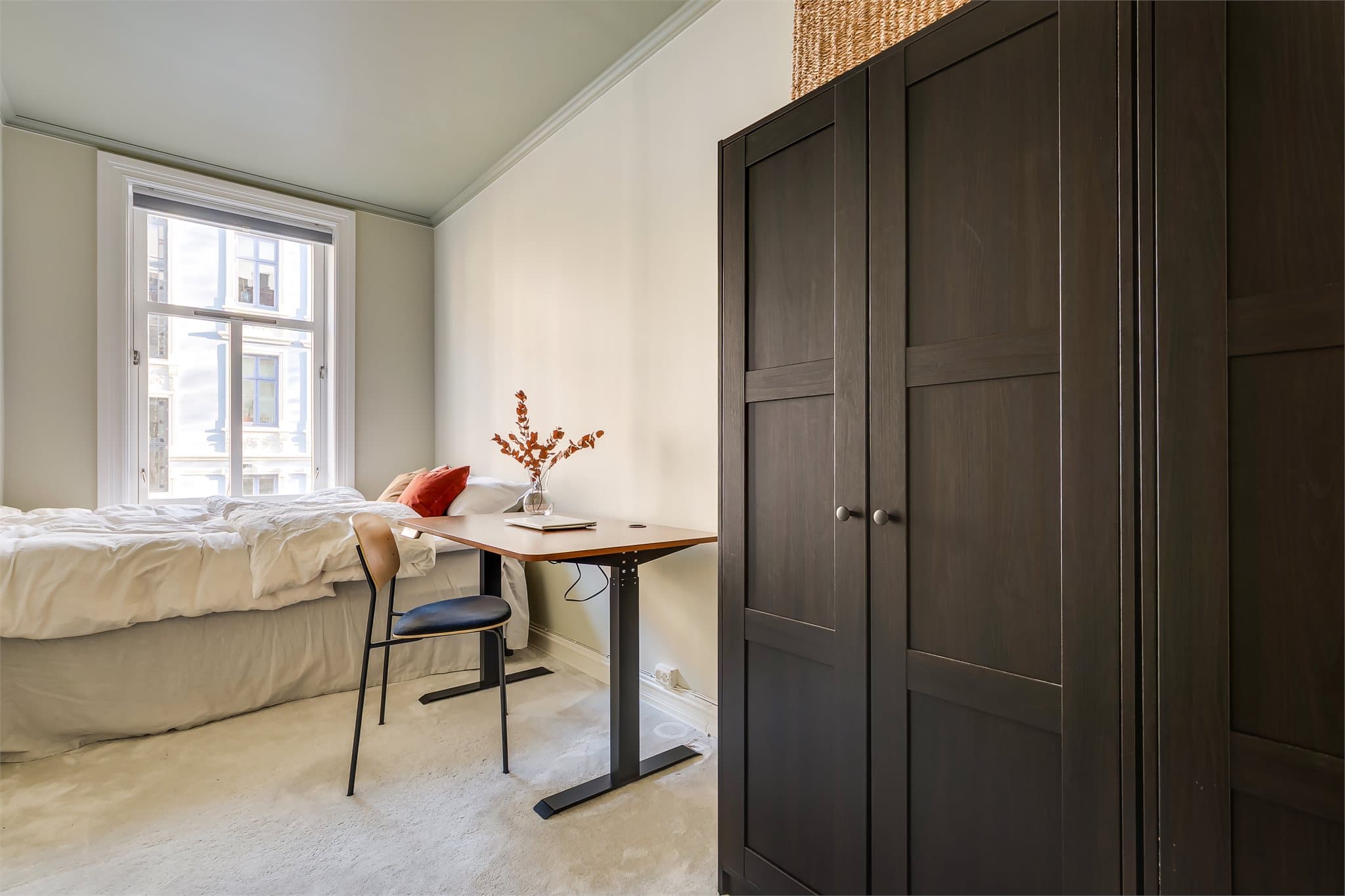 Det andre soverommet er innredet med teppe på gulvet og et romslig garderobeskap.