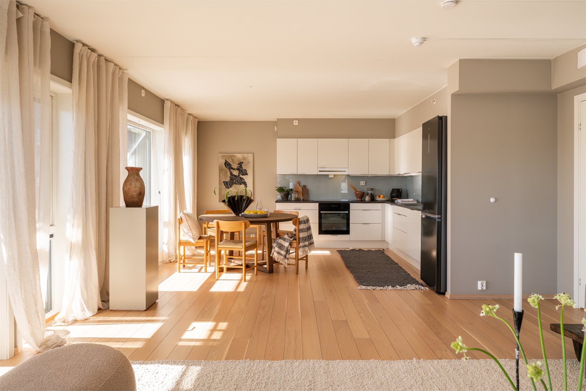 Stue og kjøkken er etablert i en åpen løsning, hvor store vindusflater sørger for rikelig med naturlig lys.