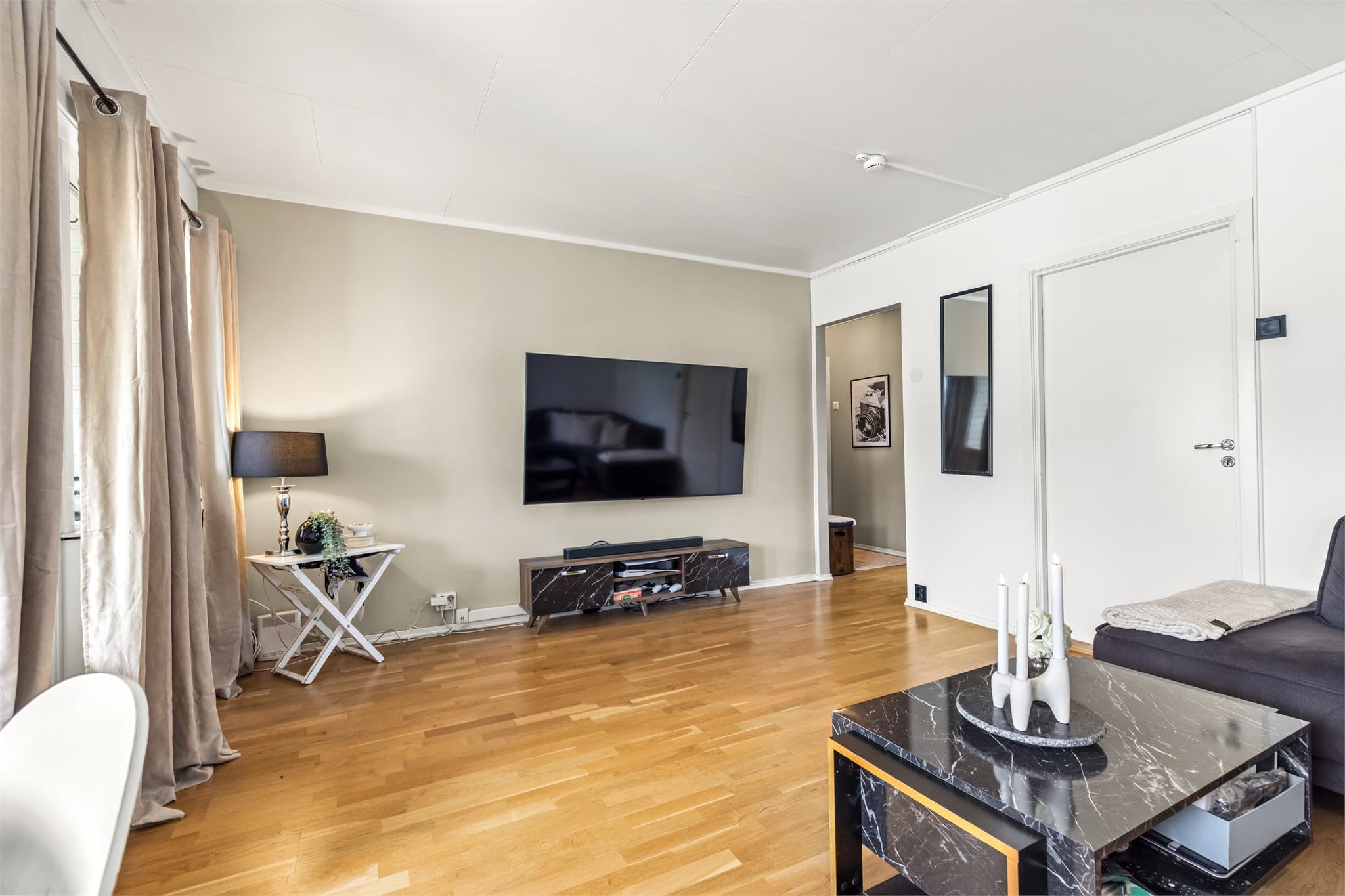 Gjennomgående parkett på gulvet binder rommene sammen og gir et helhetlig inntrykk.