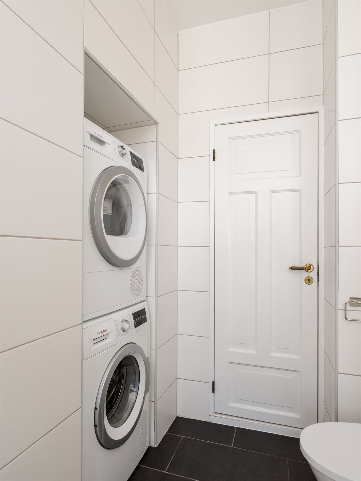 Badet er praktisk innredet med opplegg for både vaskemaskin og tørketrommel.