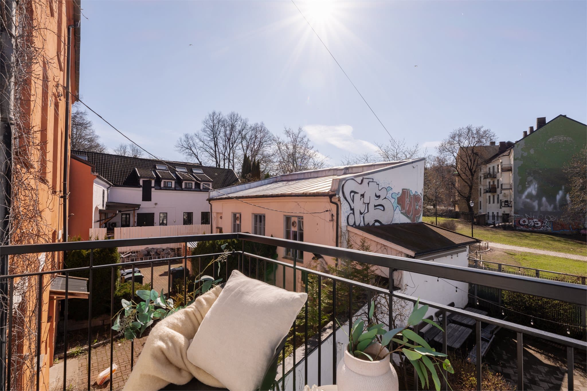 En fredelig og solrik uteplass med utsikt over borettslagets fellesarealer.