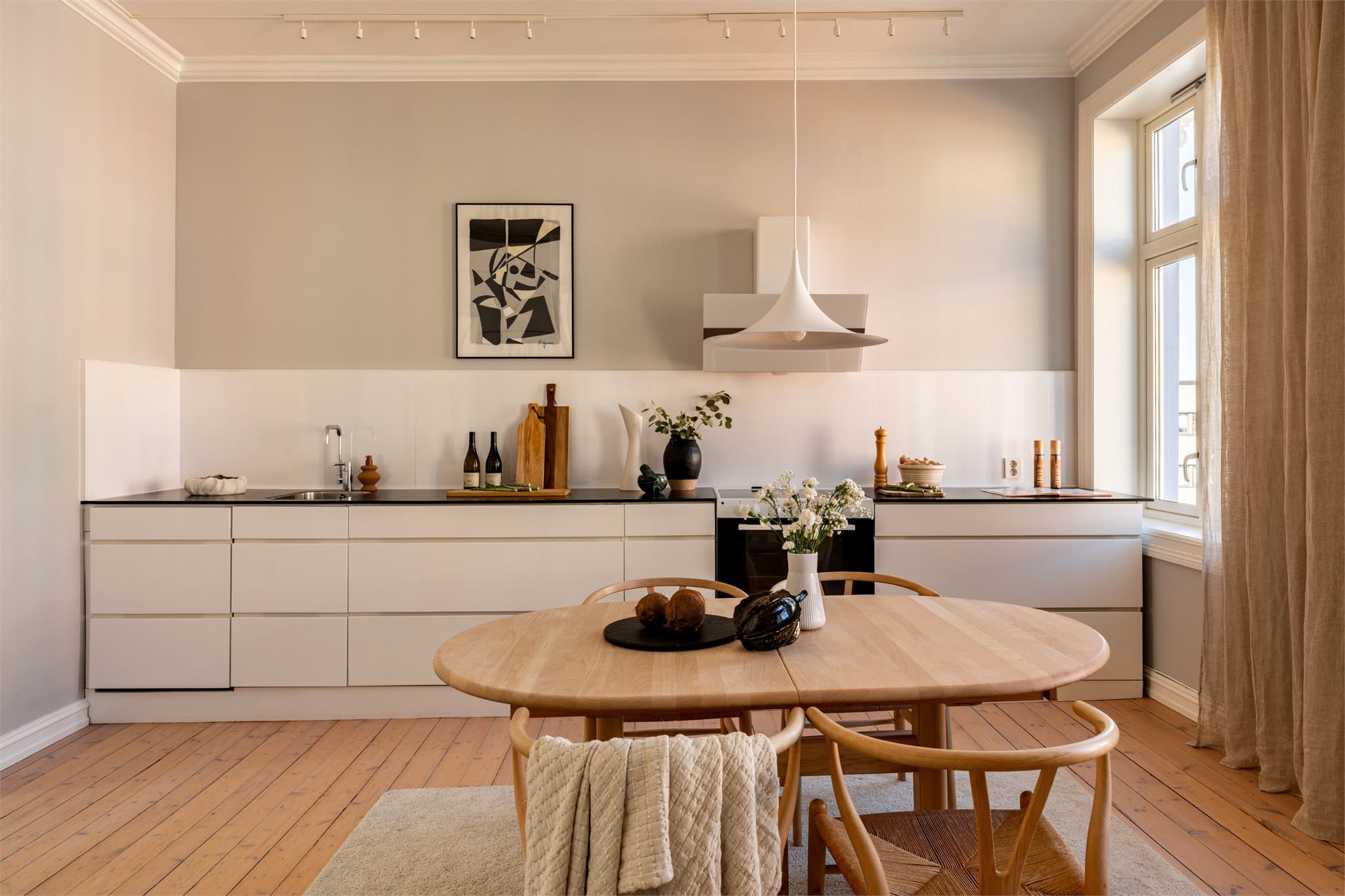 Kjøkkenet ligger i åpen og sosial forbindelse med stuen, noe som gir en naturlig flyt mellom oppholdsrommene og gode soner for både hverdagsliv og gjestebesøk.