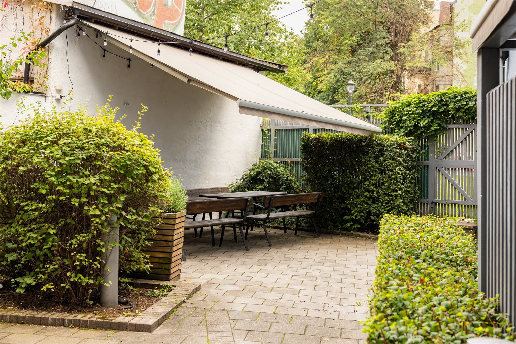 Borettslagets felles uteplass er pent opparbeidet med sittegrupper og beplantning.