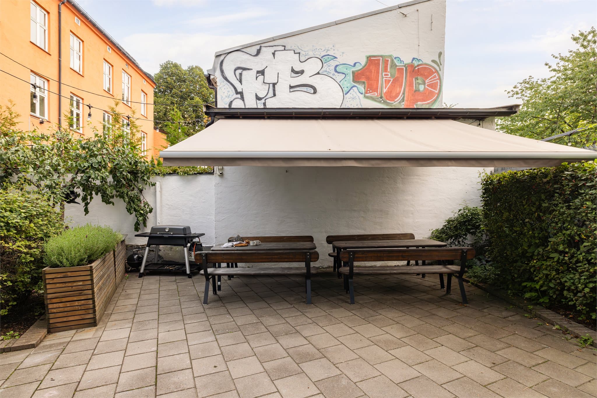 Den felles uteplassen er utstyrt med grill og langbord, perfekt for sosiale sammenkomster.