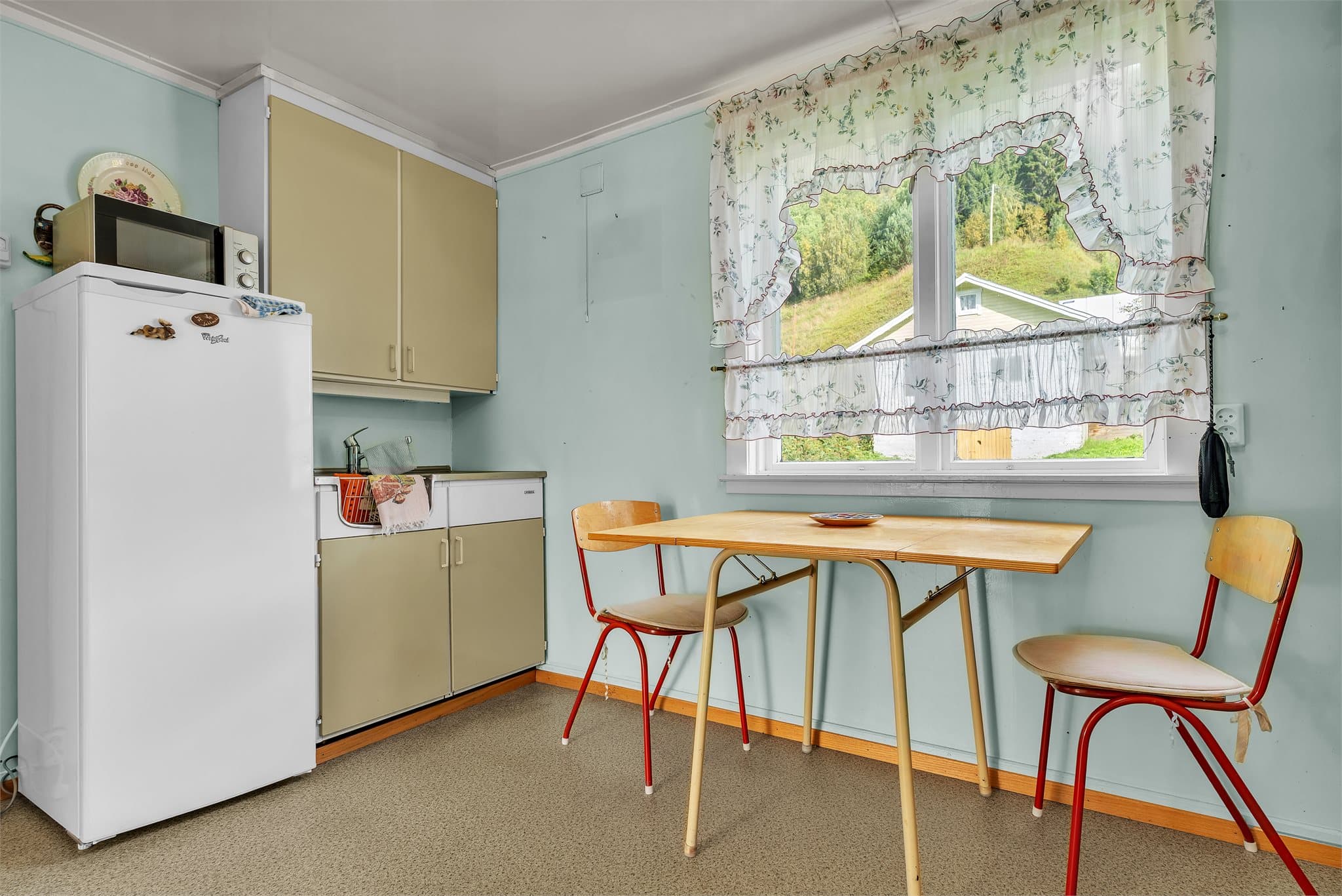 Kjøkkenet har spiseplass ved vinduet med utsyn mot hagen.
