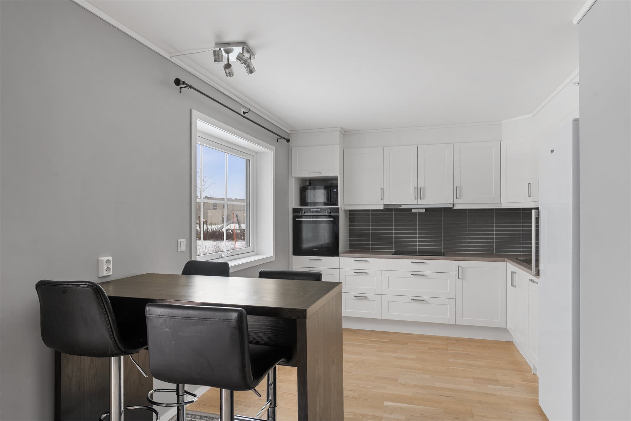 Pent, klassisk kjøkken med profilert innredning og rikelig med skap- og benkeplass.