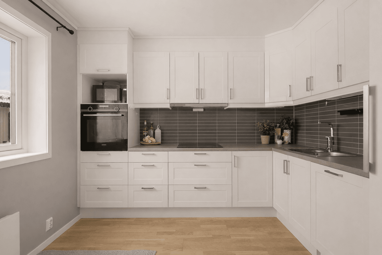 Det er dels integrerte hvitevarer og plass for frittstående kjøleskap og micro. Bildet er innredet ved hjelp av KI-verktøy.