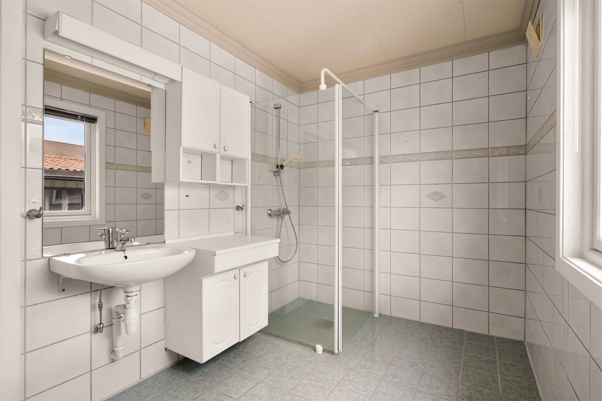 Romslig baderom med flislagte overflater og varme i gulvet.