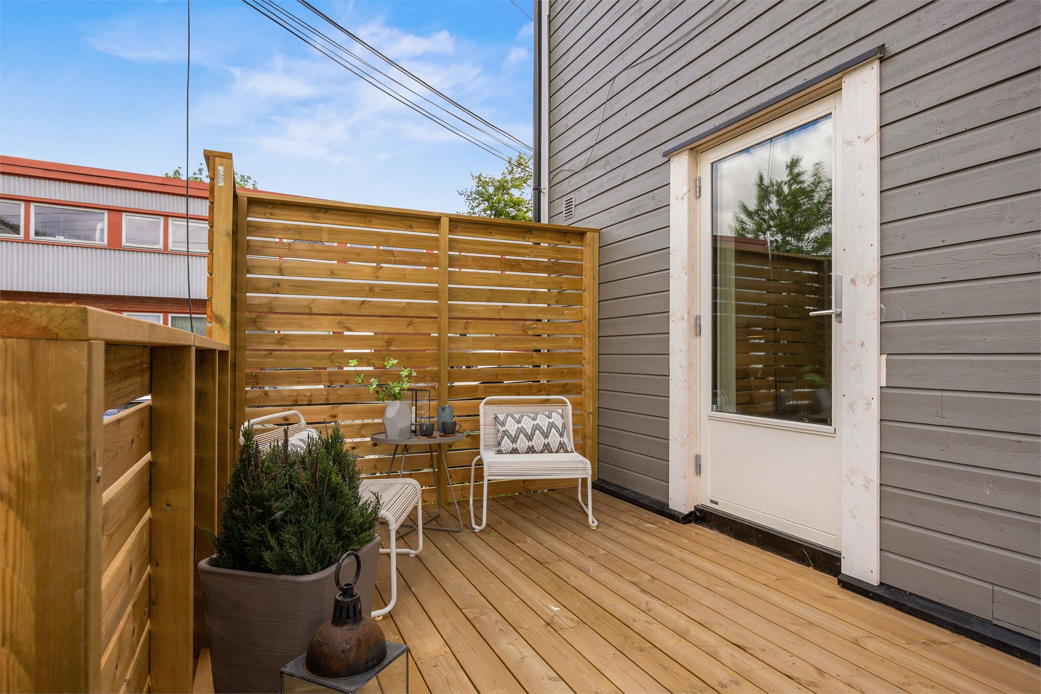 Leiligheten har hele tre uteplasser: en terrasseplatting på ca. 8,6 m² ved inngang, en overbygd terrasse på ca. 3,2 m² med malte levegger, og en østvendt markterrasse på ca. 7,4 m² med utgang direkte fra stuen.