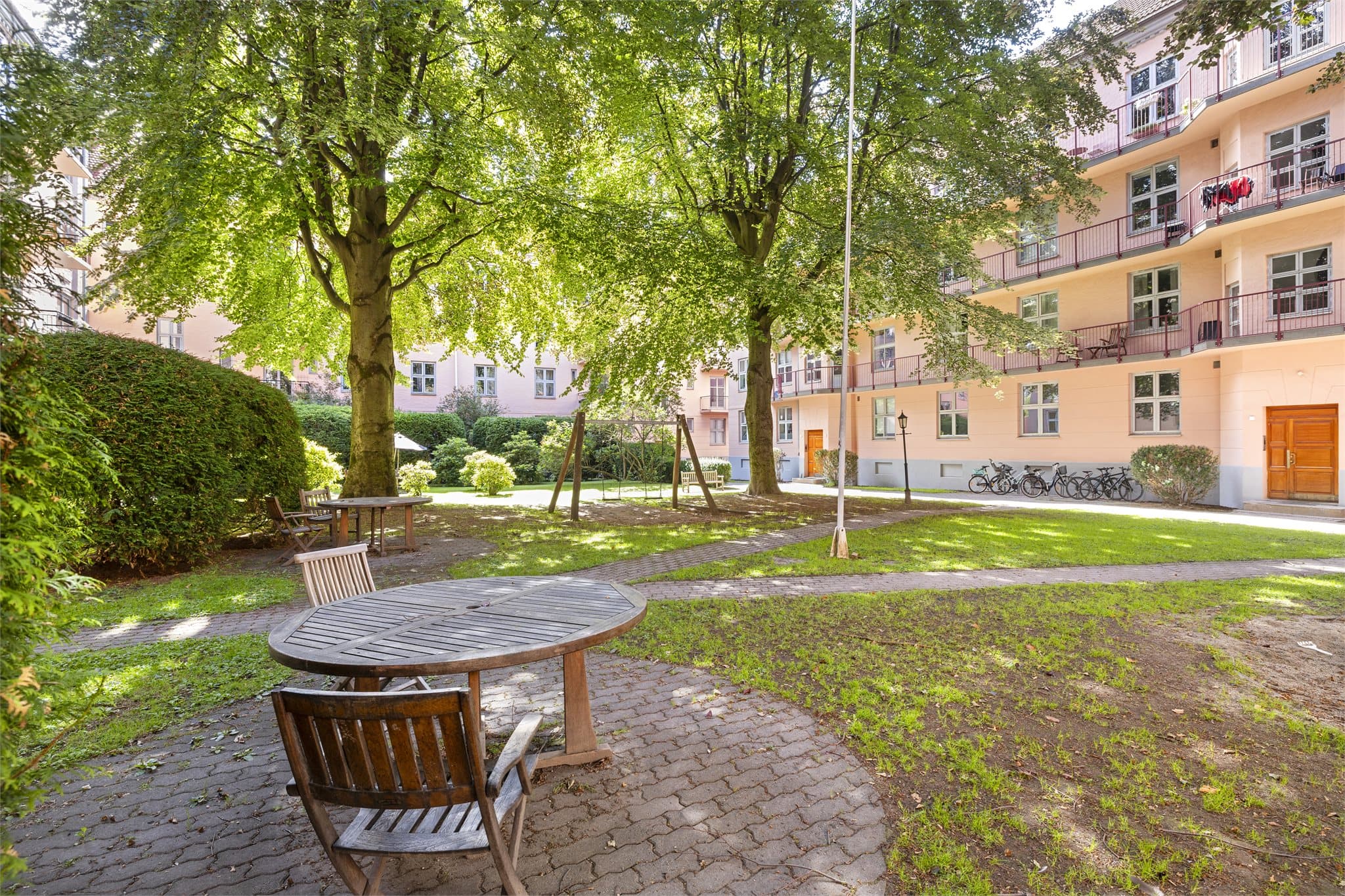 Store trær og grøntarealer skaper en parkmessig følelse i bakgården.