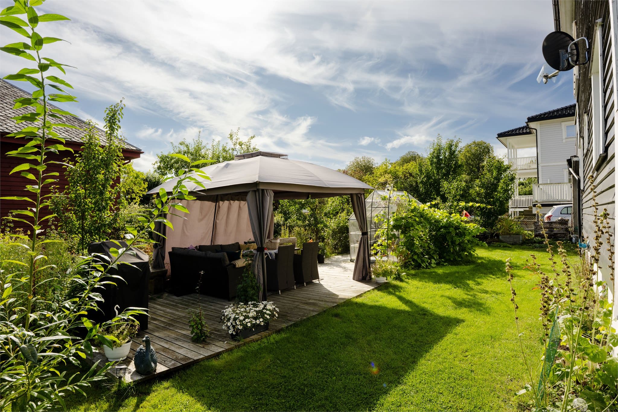Skjermet uteplass på treplatting med god plass til grill og utemøbler.