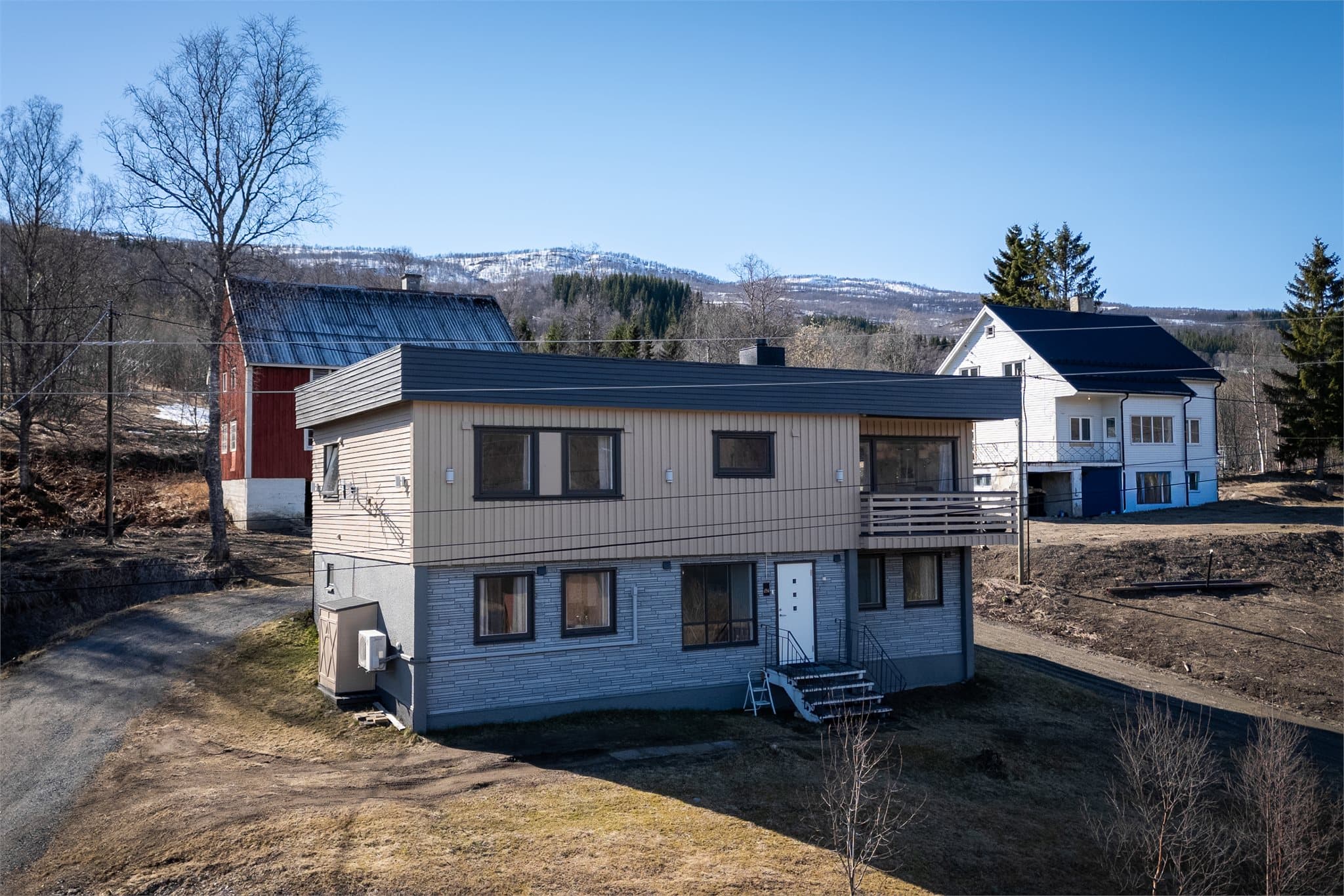 Hage og parkering på eiendommen, inngang til boligen fra to sider