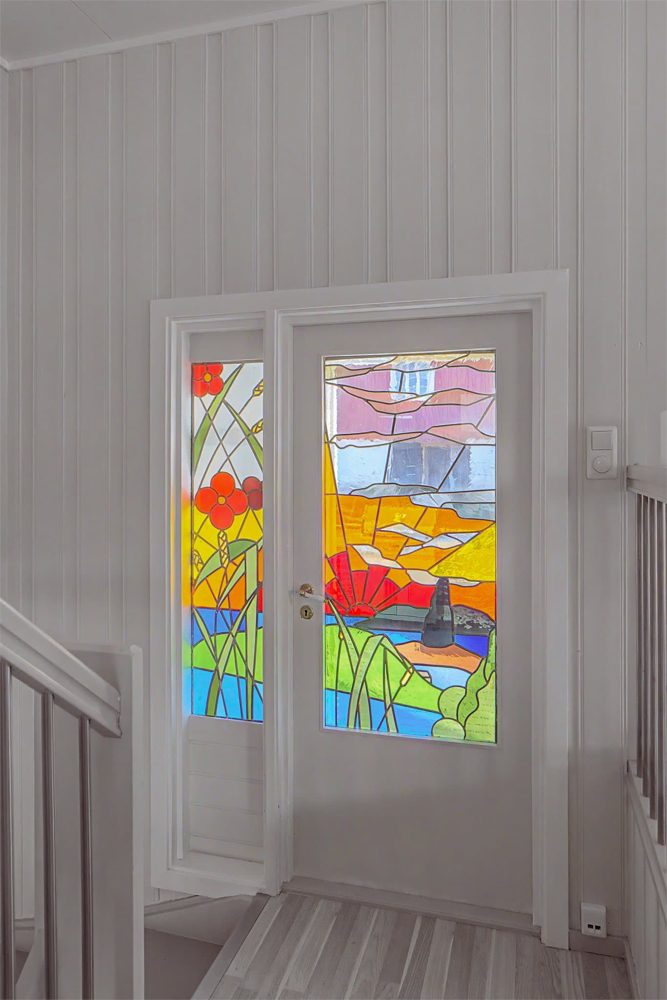 En dør med glassmaleri mellom stuen og vindfanget i 1. etasjen gir et unikt preg på interiøret.