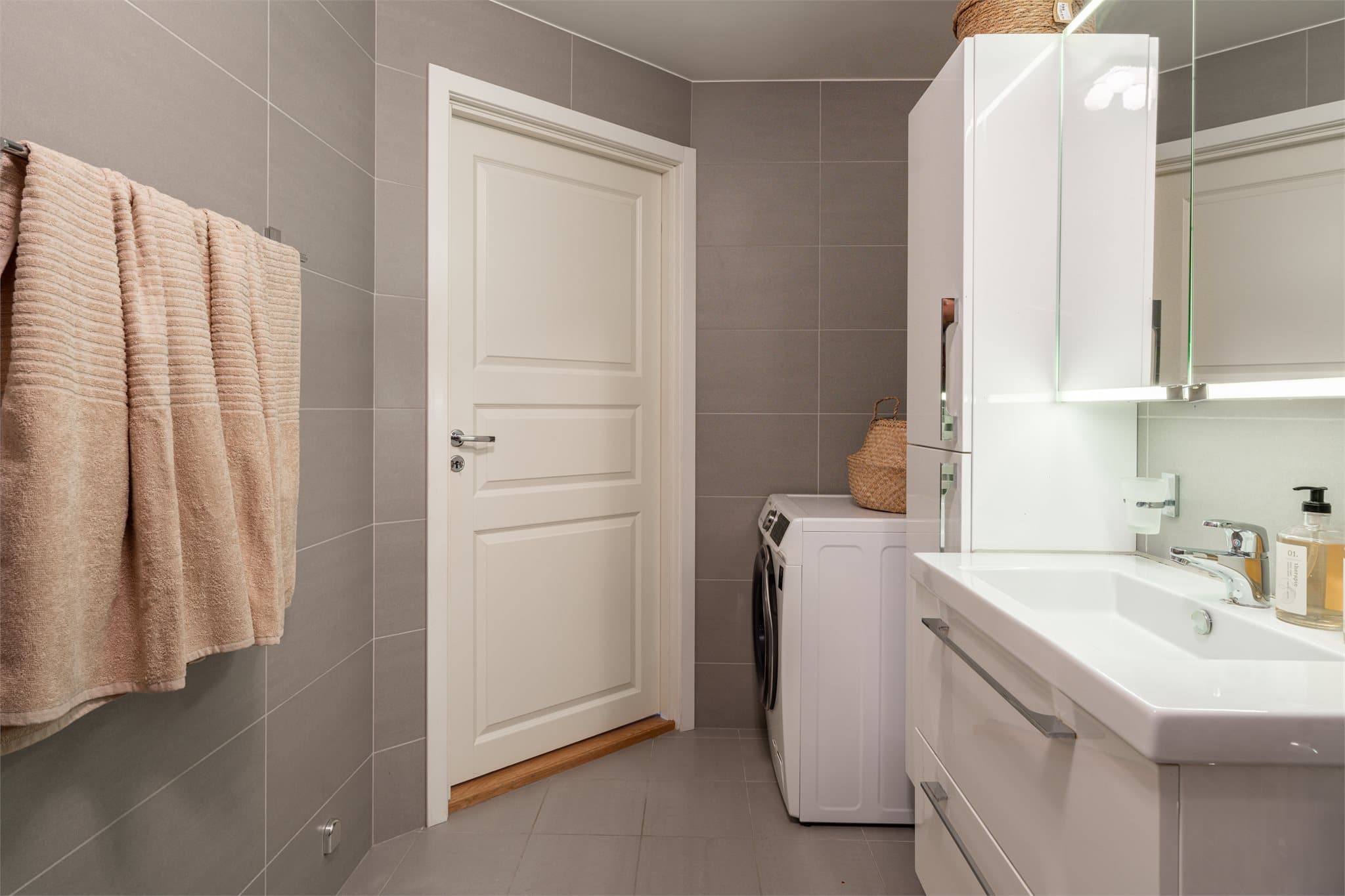 Badet har opplegg for vaskemaskin og ekstra oppbevaringsplass i høyskap.