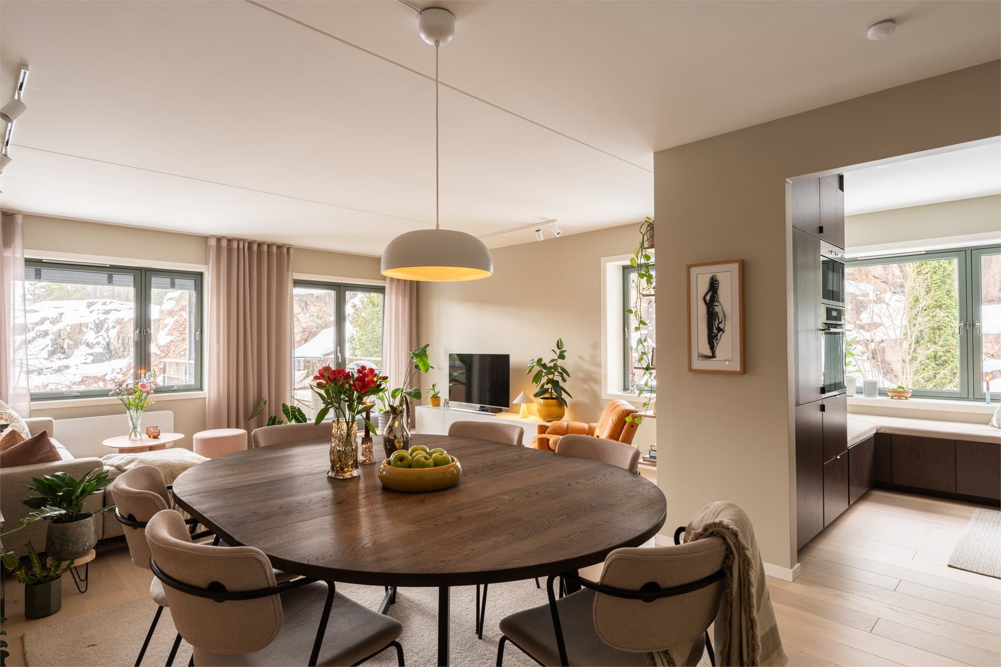 Den åpne løsningen mellom stue og kjøkken skaper en sosial atmosfære, men likevel delt opp med en vegg som gir begge "rommene" flere møbleringsmuligheter.