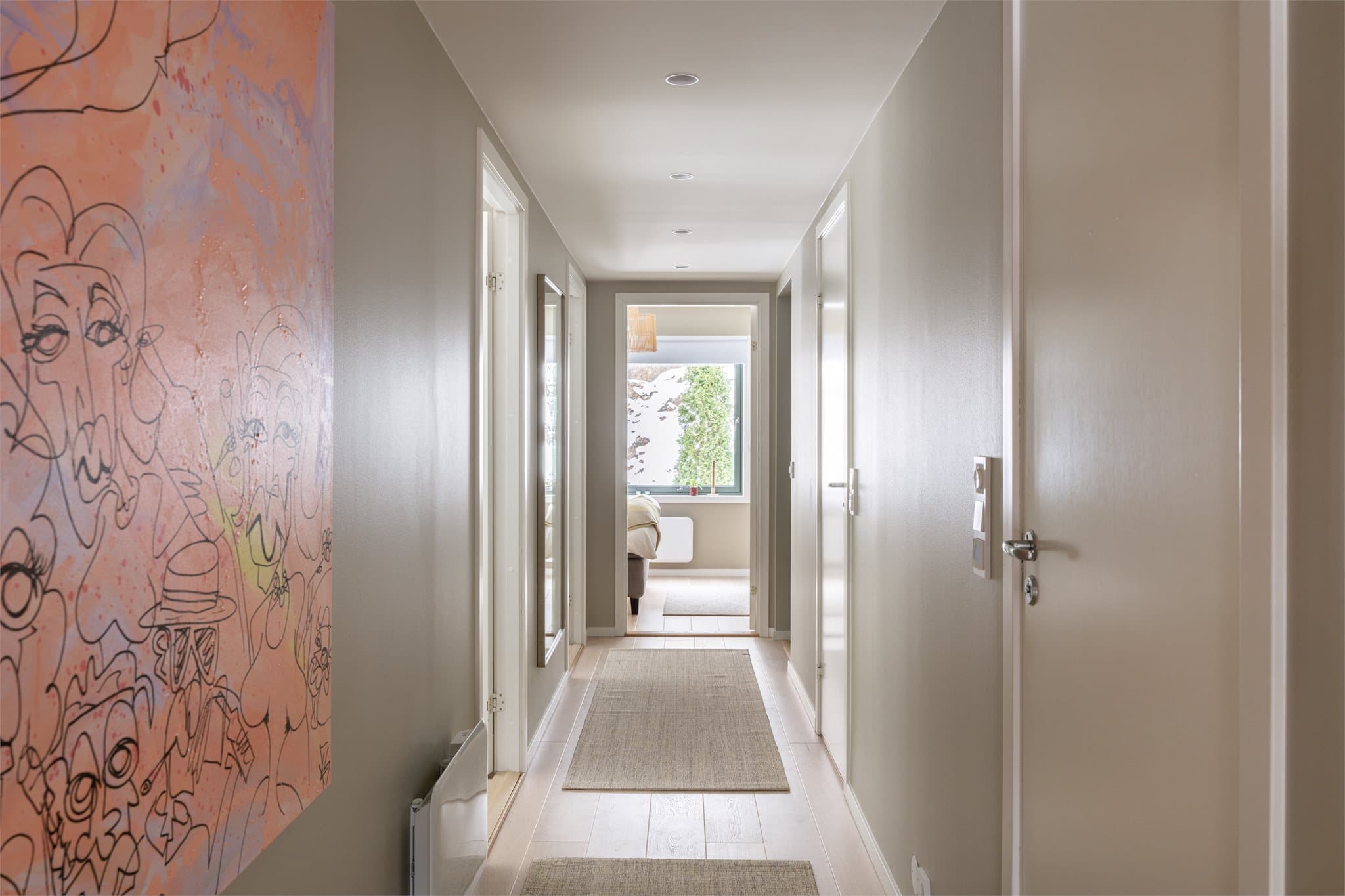 Vi beveger oss videre inn i leilighetens private del via en lys og pen gang.