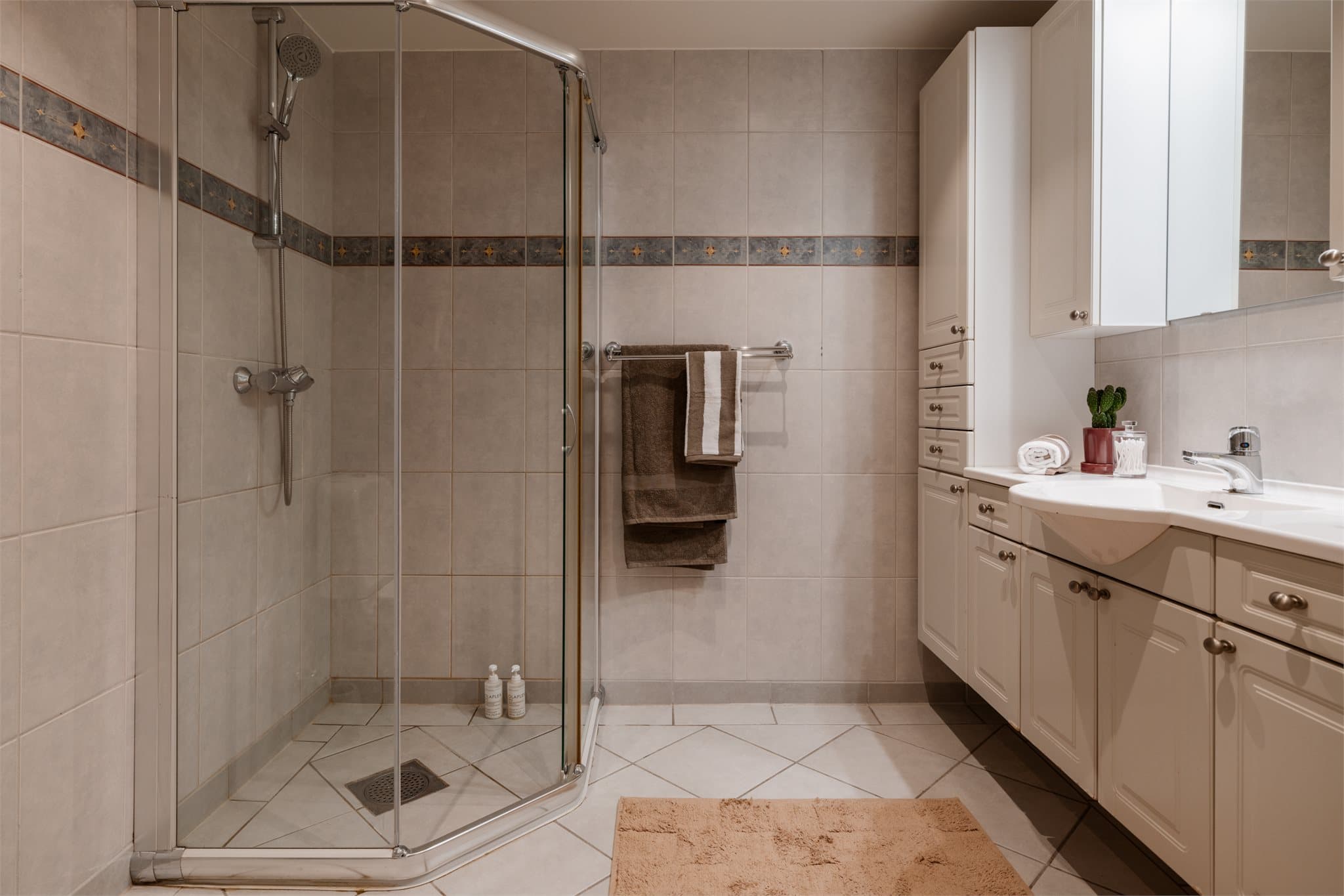 Hovedbadet er helfliset og har en romslig dusjnisje med innfellbare glassdører.