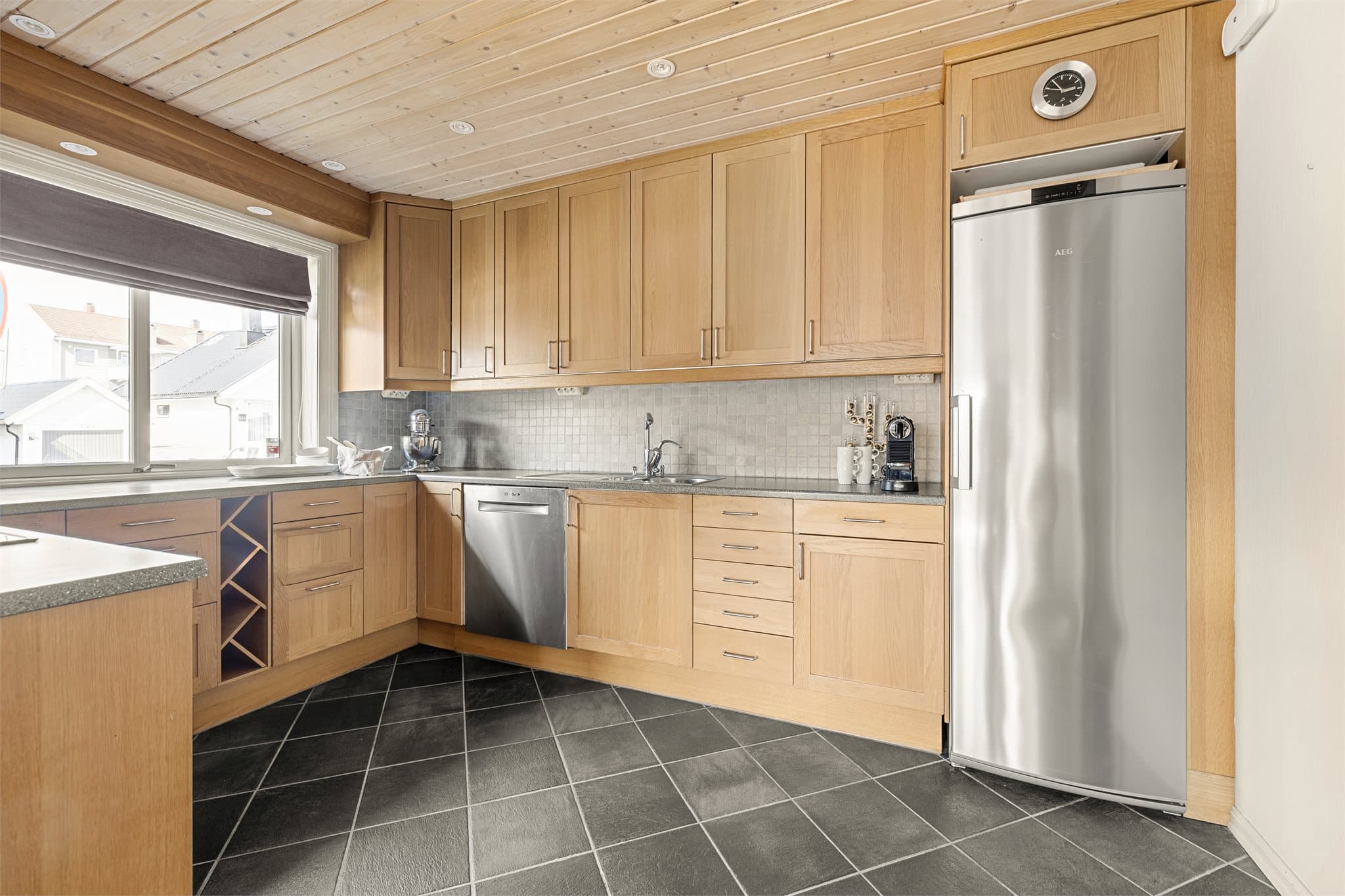 Det er fliser over benkeplate og belysning under overskap.