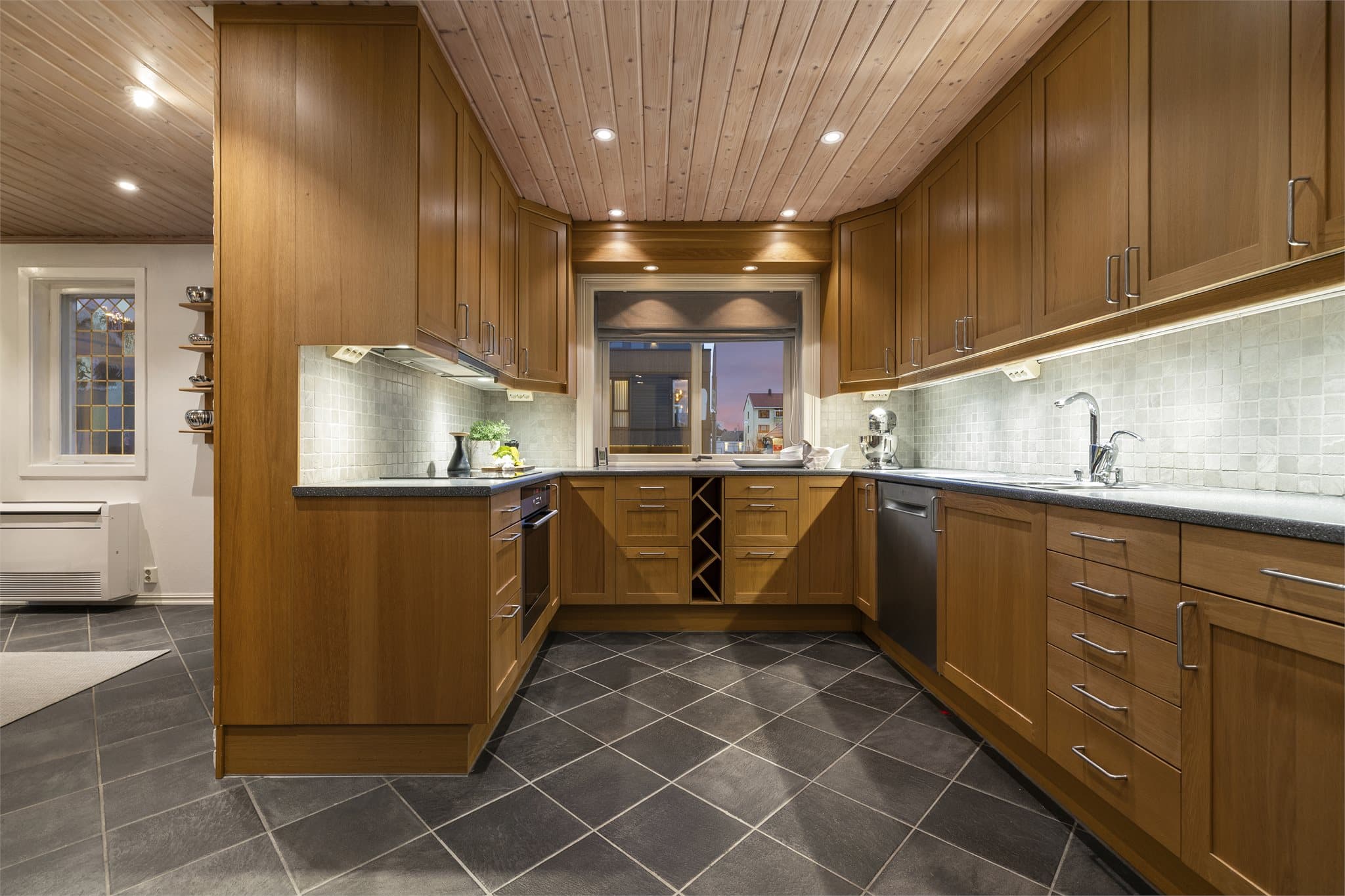 Kjøkkenet har innredning fra Ikea fra 2004 med profilerte fronter i heltre og laminert benkeplate med nedfelt kum i rustfritt stål.