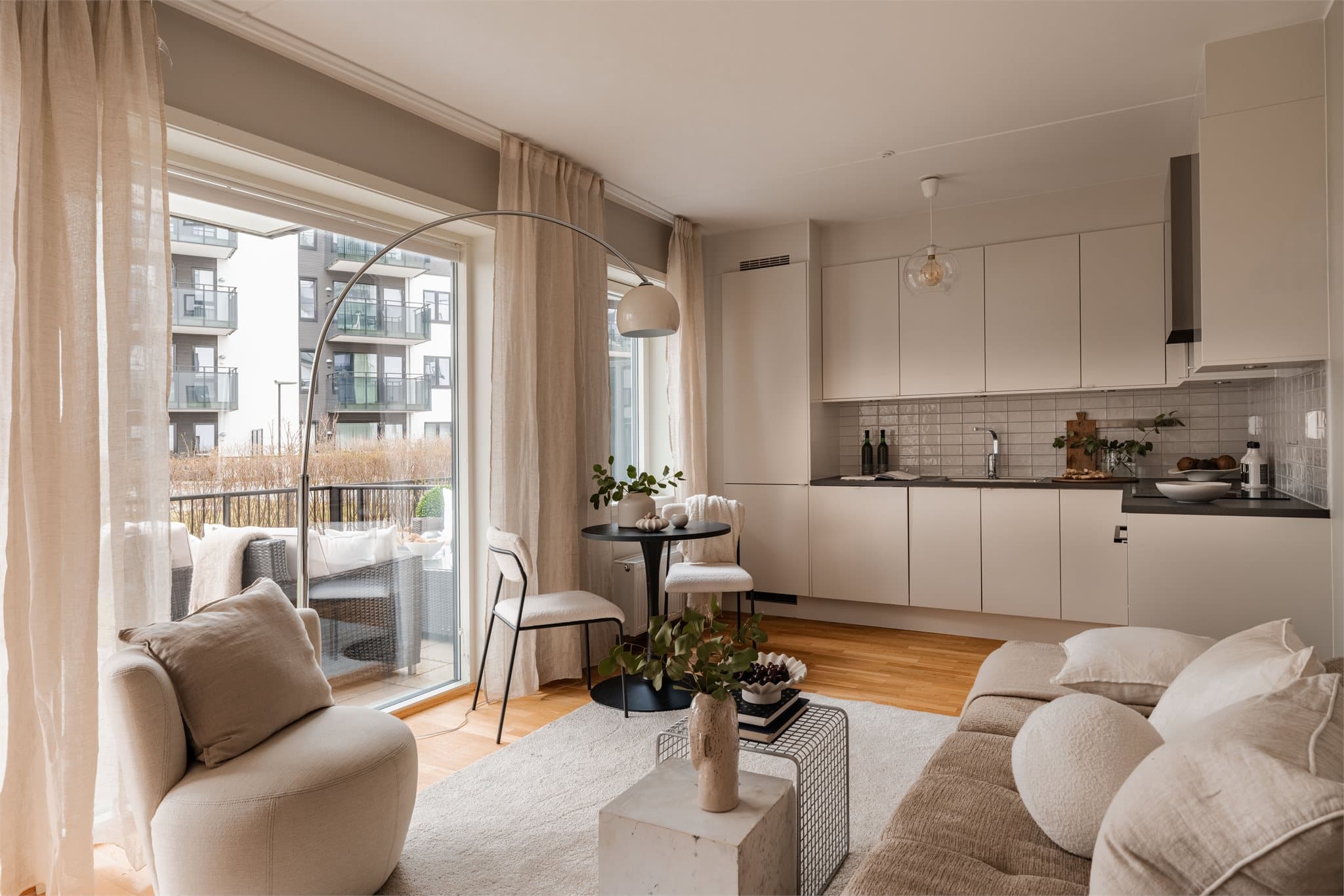 Store vindusflater og dør til uteplassen gir rikelig med naturlig lys til oppholdsrommet.