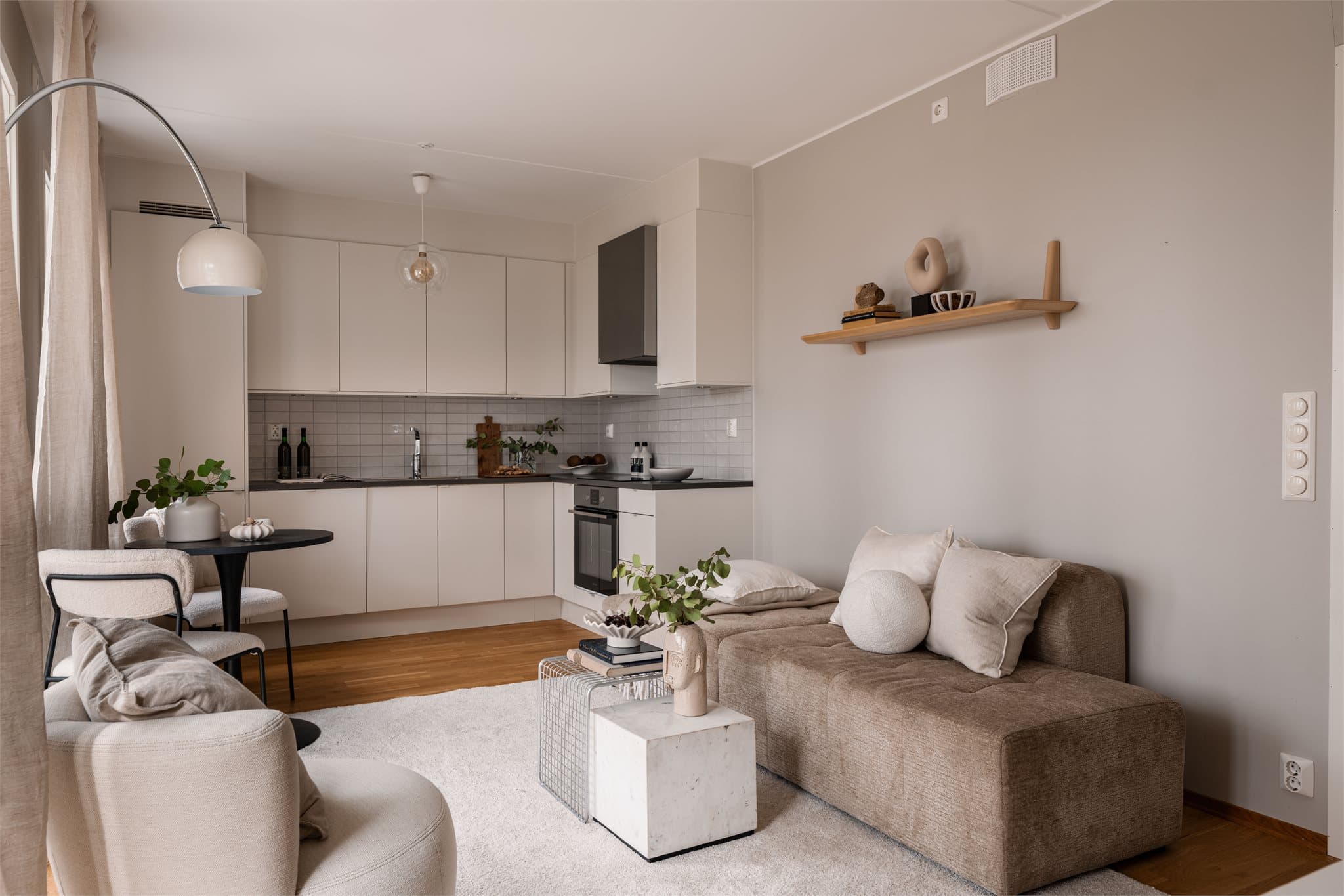 Den åpne løsningen mellom stue og kjøkken skaper en sosial og luftig atmosfære.