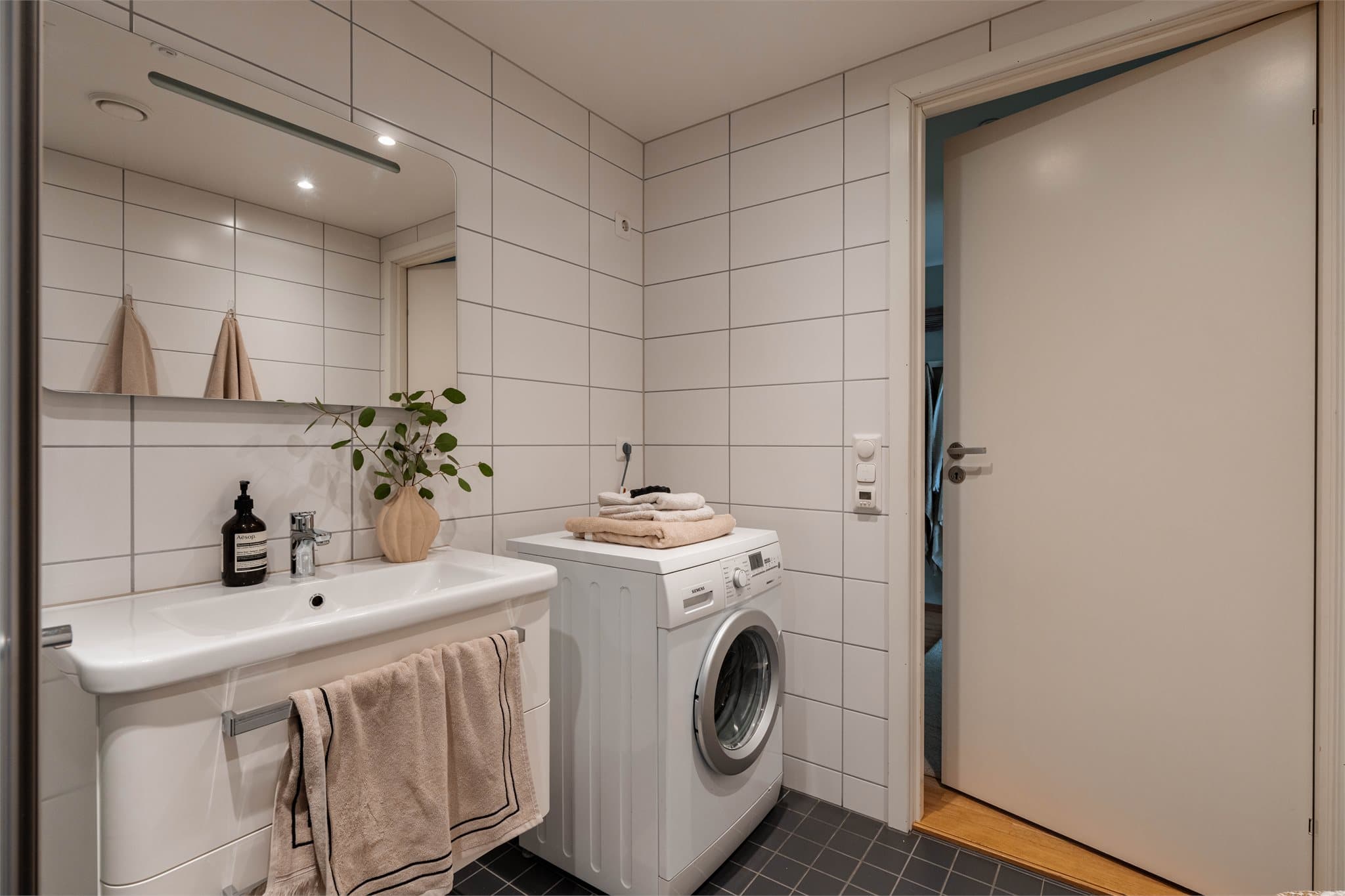 Badet er praktisk innredet med opplegg for vaskemaskin, vegghengt toalett og dusjhjørne.