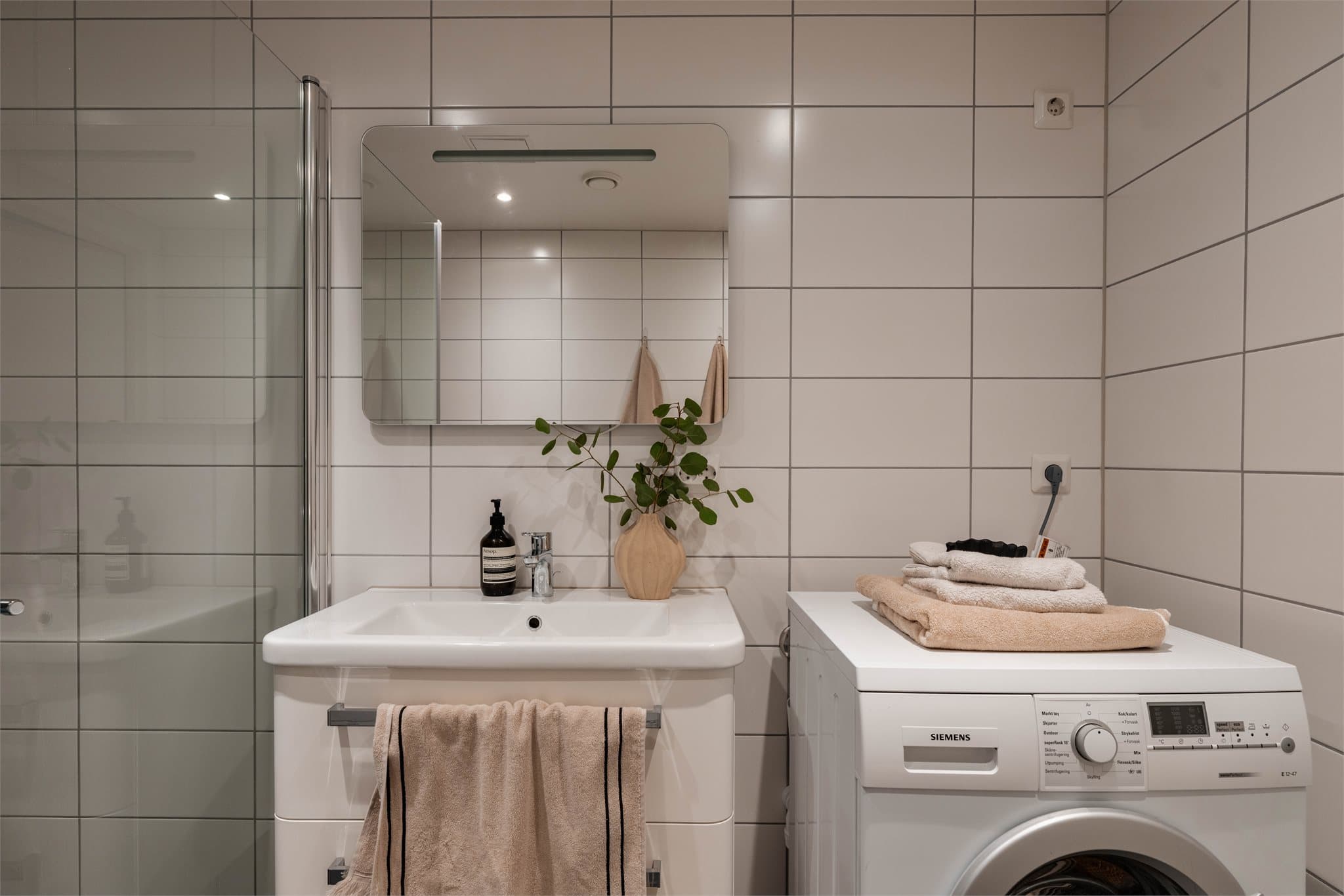 Innredning med nedfelt servant og speilskap gir god oppbevaringsplass.