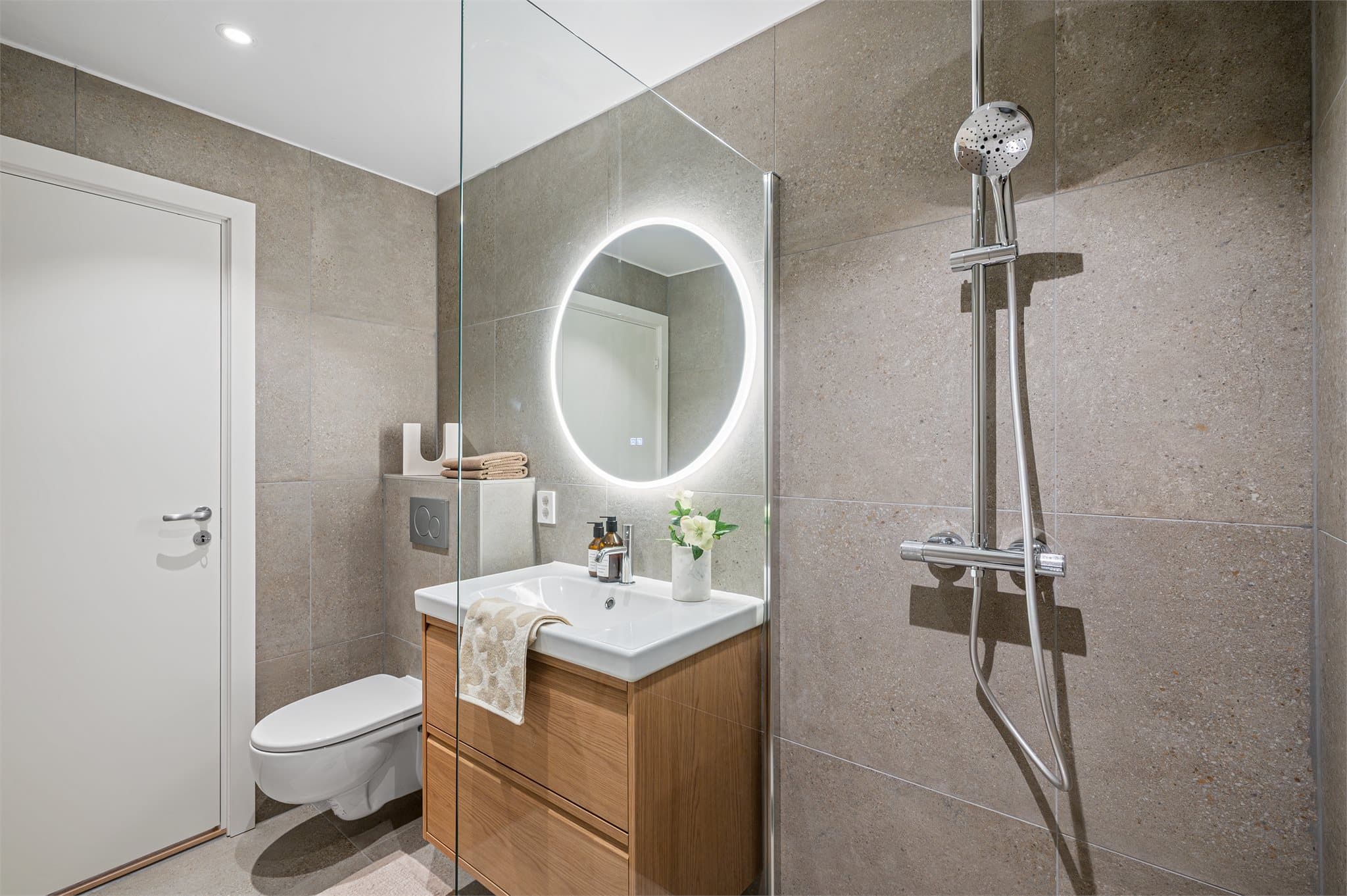 - Innredet med vegghengt toalett, benkeskap med servant og dusjvegg i glass. Varme i gulvet -